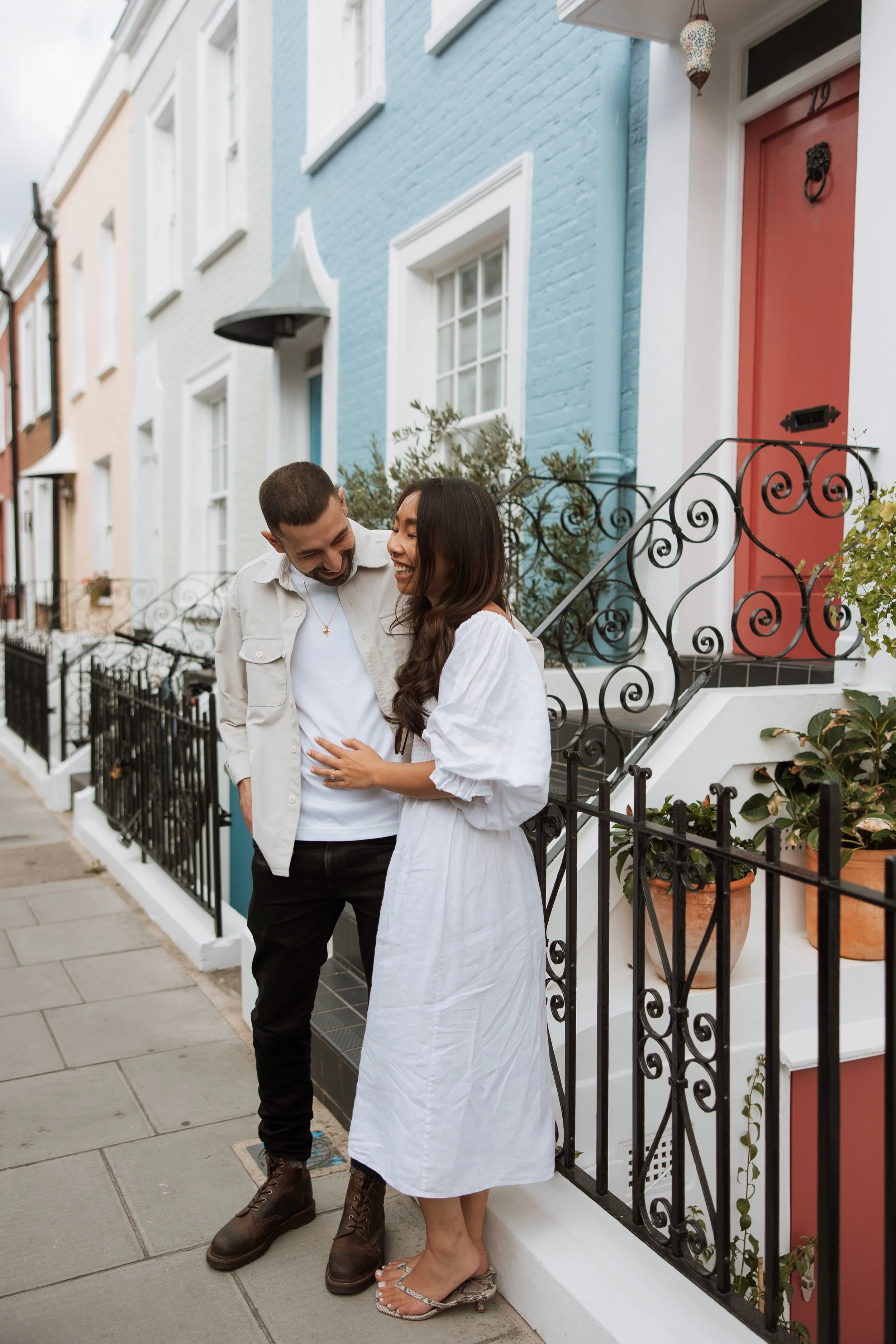 Couple laughing during a relaxed pre-wedding shoot in Nottinghill, London, feeling comfortable in front of the camera with their wedding photographer