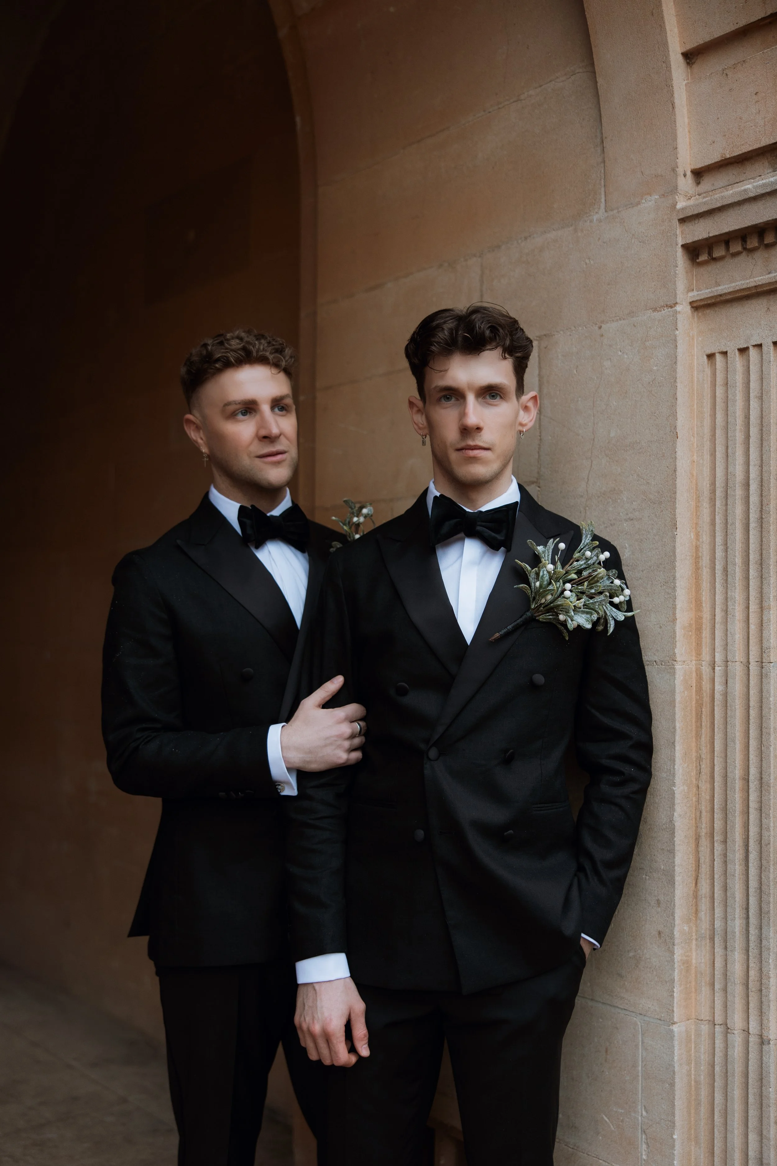 same sex couple wearing tuxedos doing editorial pose on their wedding day at coombe lodge near bristol