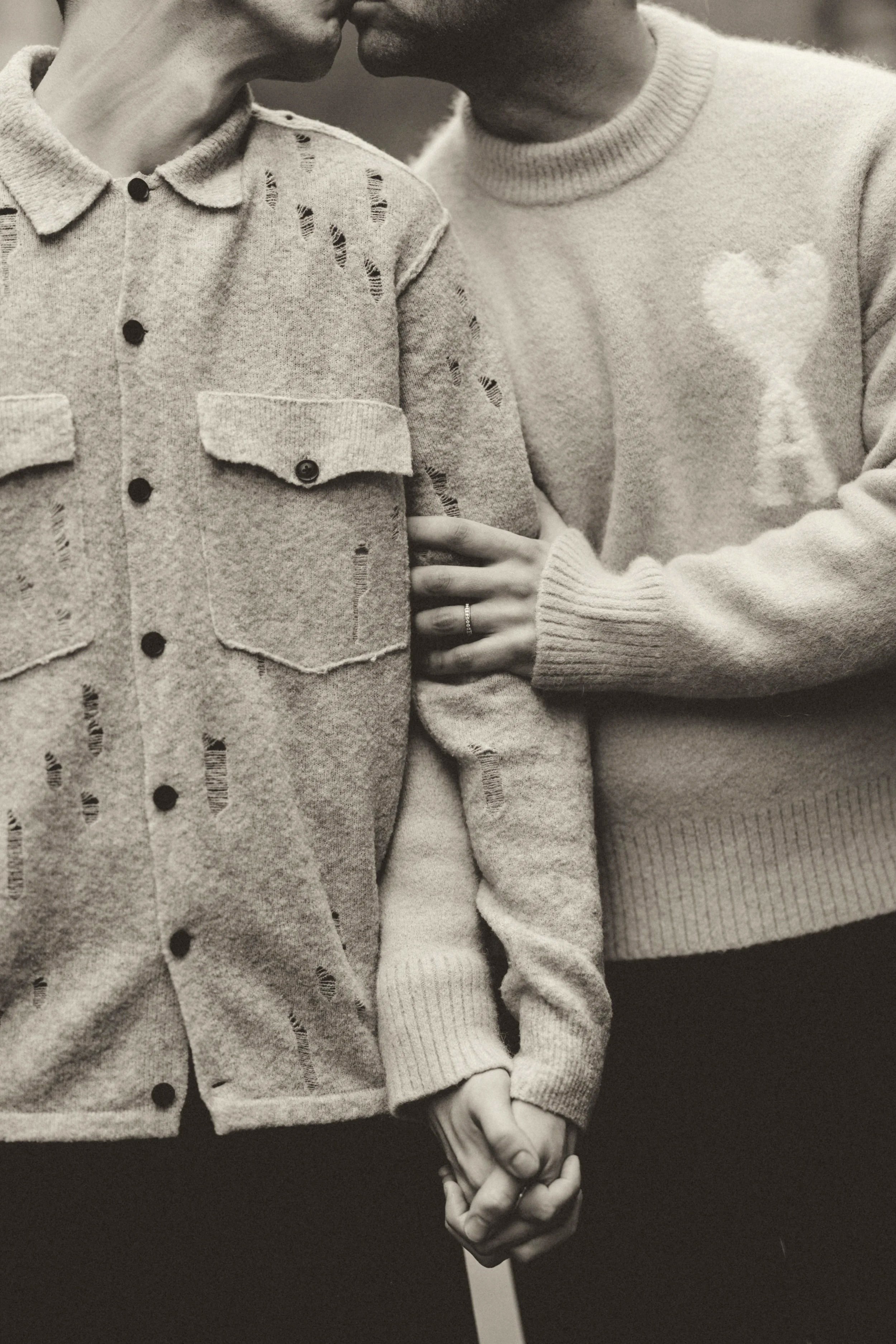 same sex gay male couple kissing during engagement photoshoot. Outfit inspiration for pre wedding photoshoot with timeless and fashion-led styling