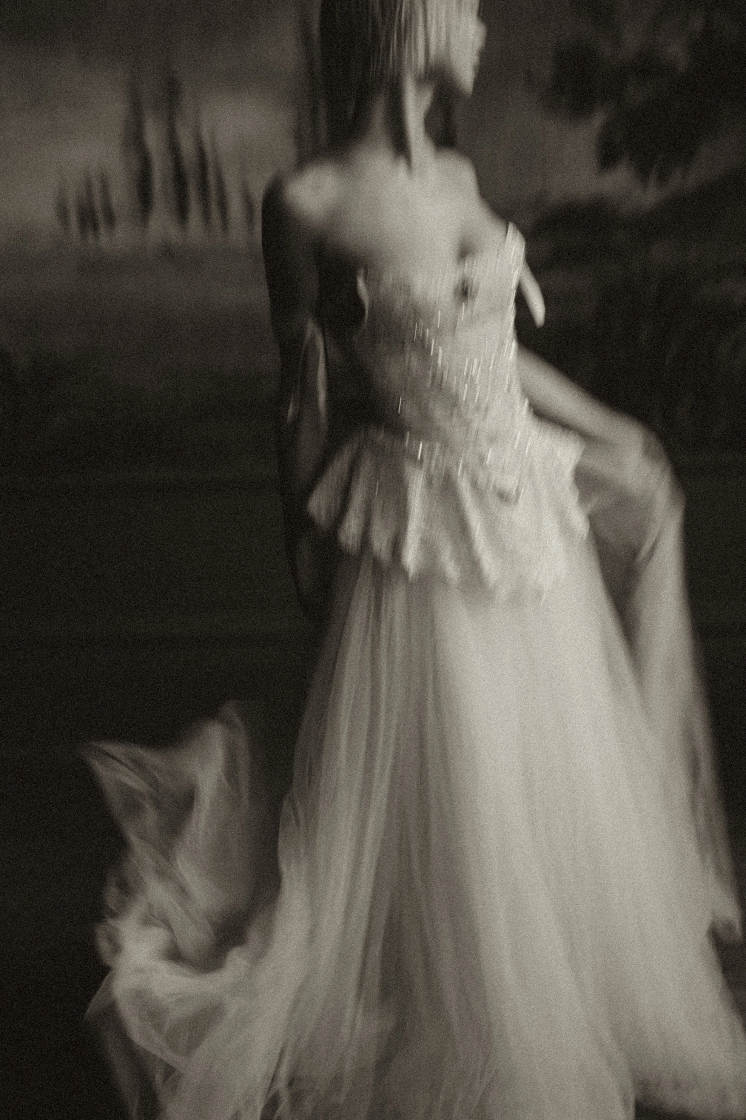 A woman wearing an elegant wedding dress in a dimly lit room at a bridal editorial photoshoot.