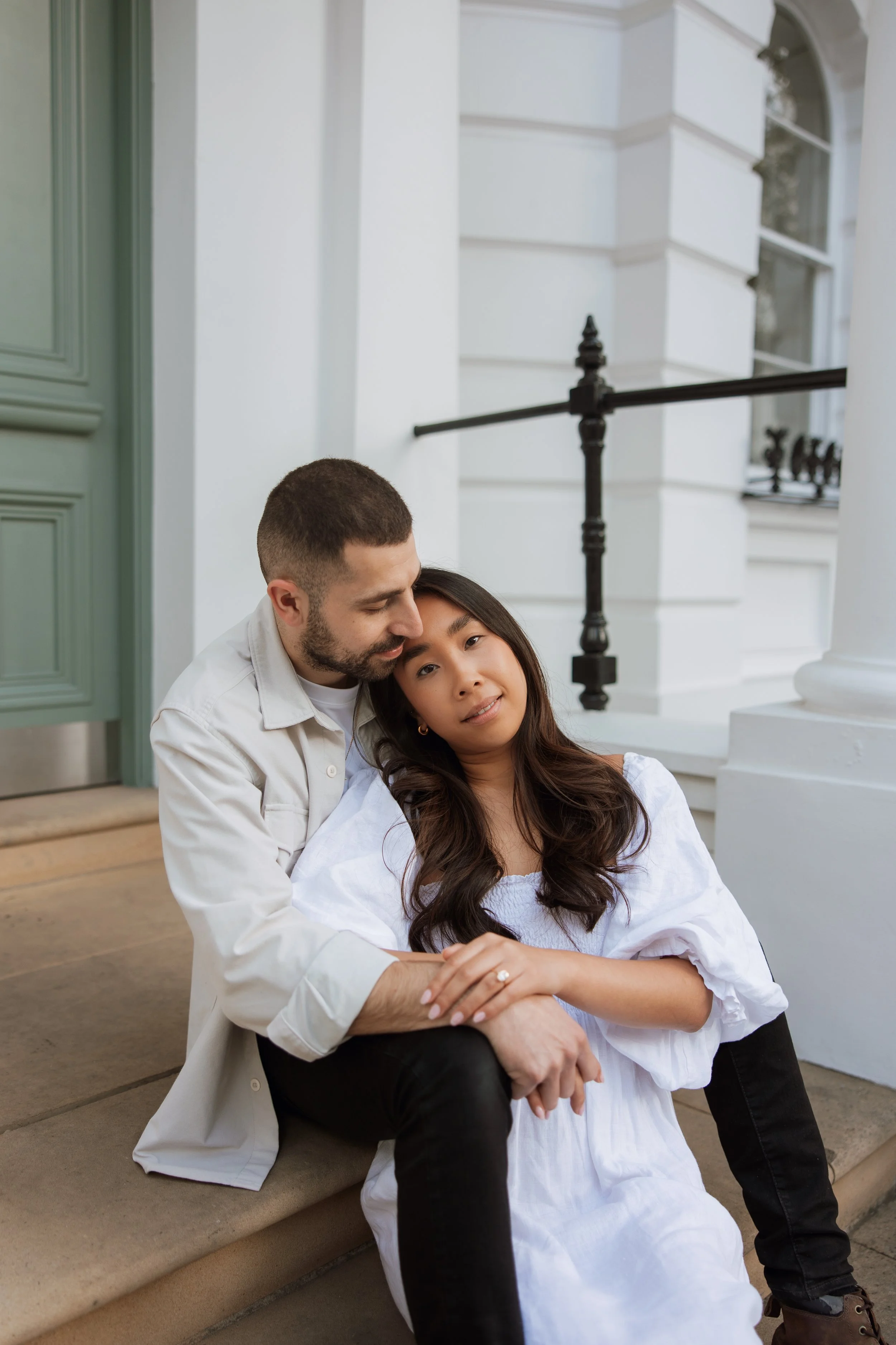 Couple sat on steps in front of house in Notting Hill, London. Timeless engagement photos in the UK with a refined, editorial wedding photography style