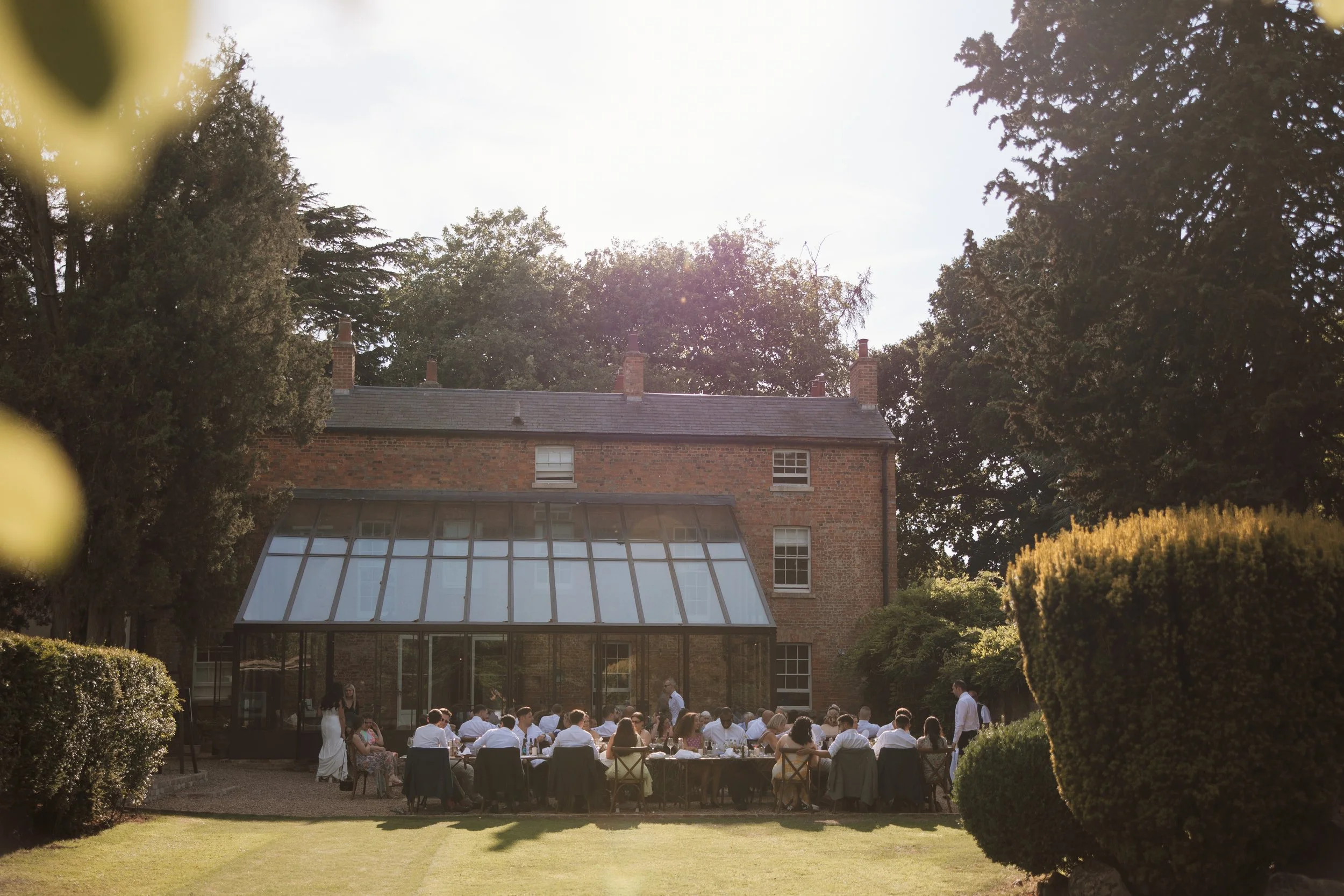 Wedding guests dining outside at summer wedding at Aswarby Rectory