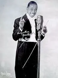 Jimmie Lunceford, Memphis bandleader, singing into a vintage microphone, smiling, dressed in formal attire with a bow tie, performing with a baton in hand.