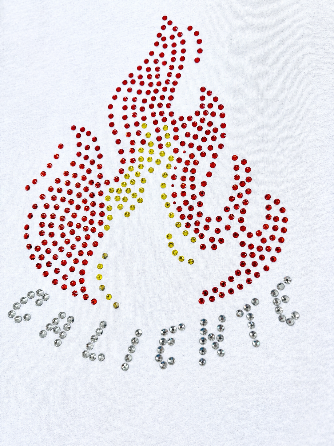 Camiseta blanca ajustada para mujer con diseño de fuego en rhinestones rojos y amarillos y la palabra “Caliente”.