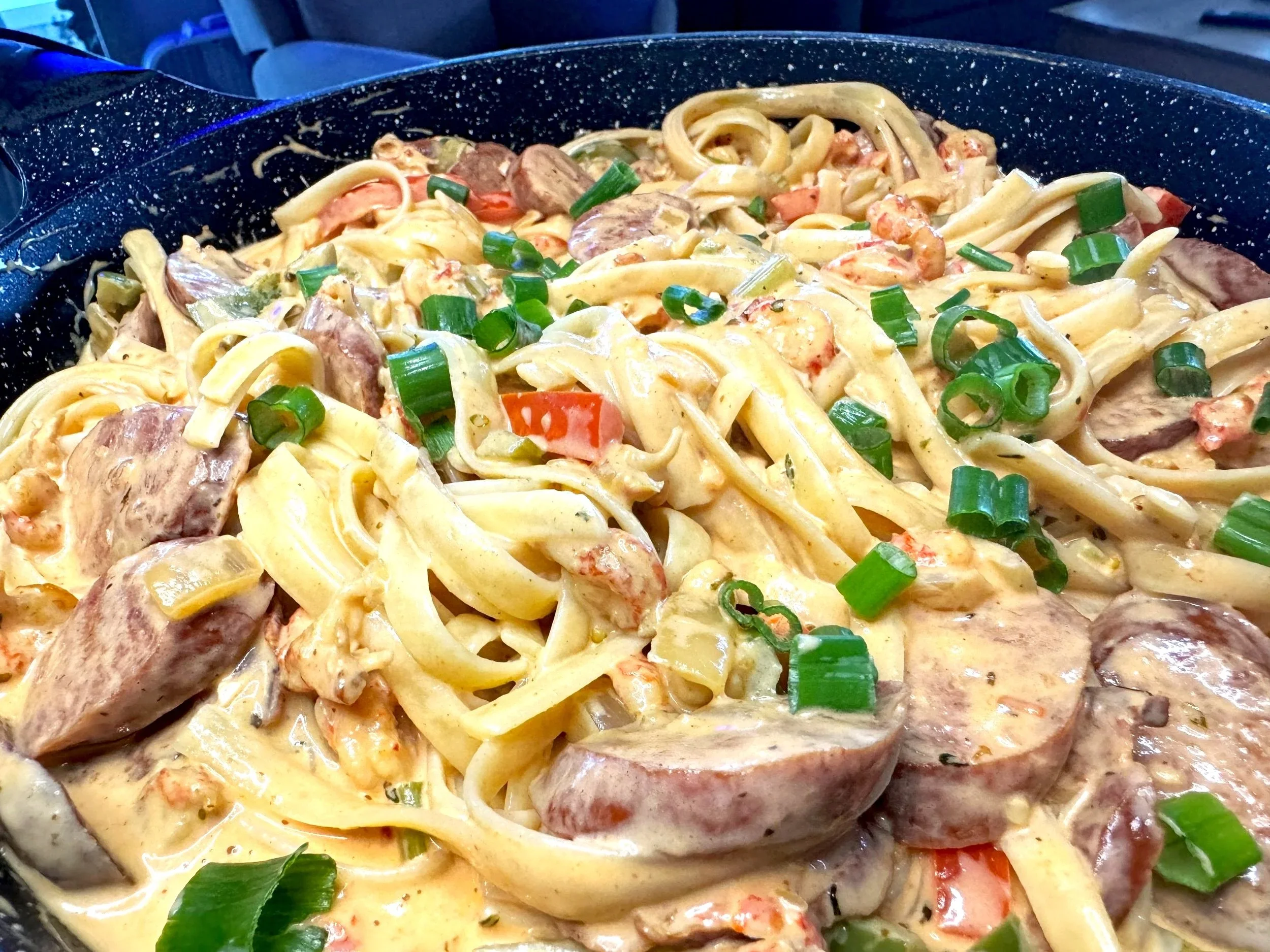 Creamy Cajun sausage and crawfish fettuccine topped with green onions