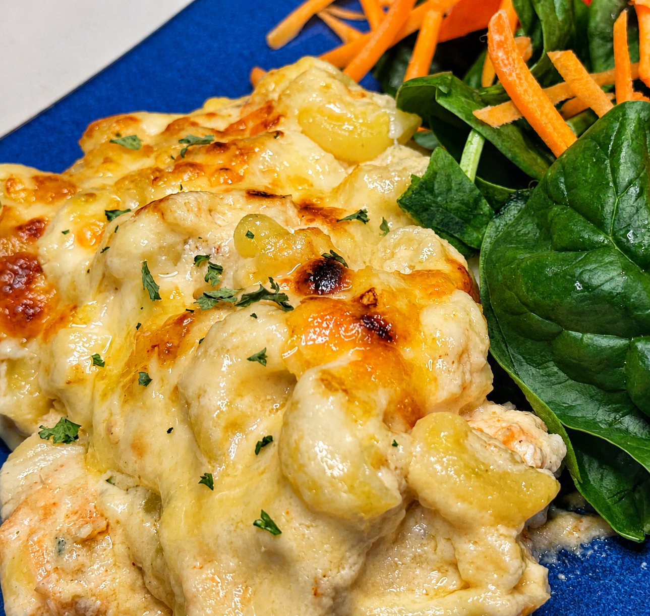 Creamy smoky salmon mac and cheese served with fresh spinach salad