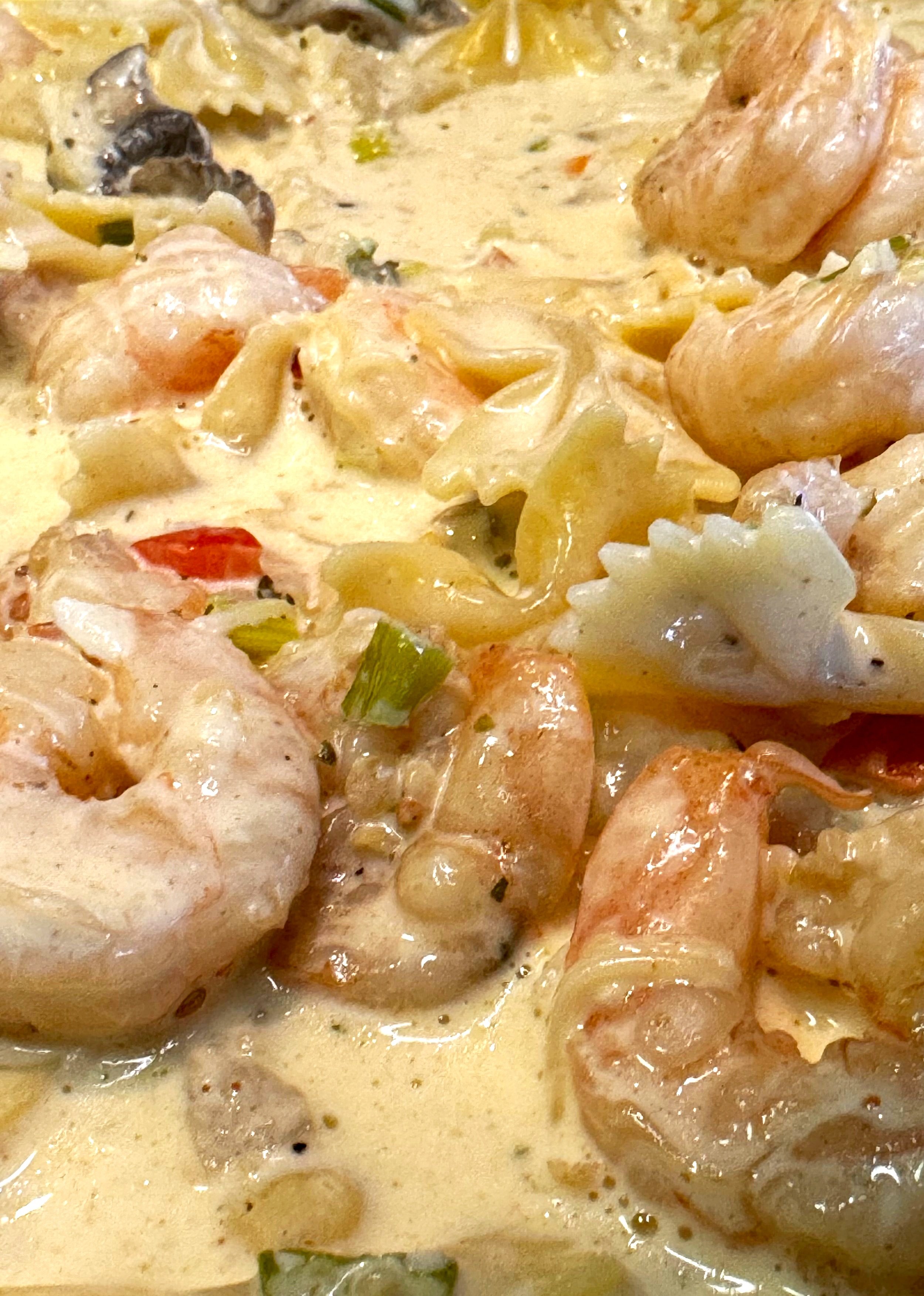 A creamy plate of juicy shrimp Alfredo pasta topped with parmesan cheese