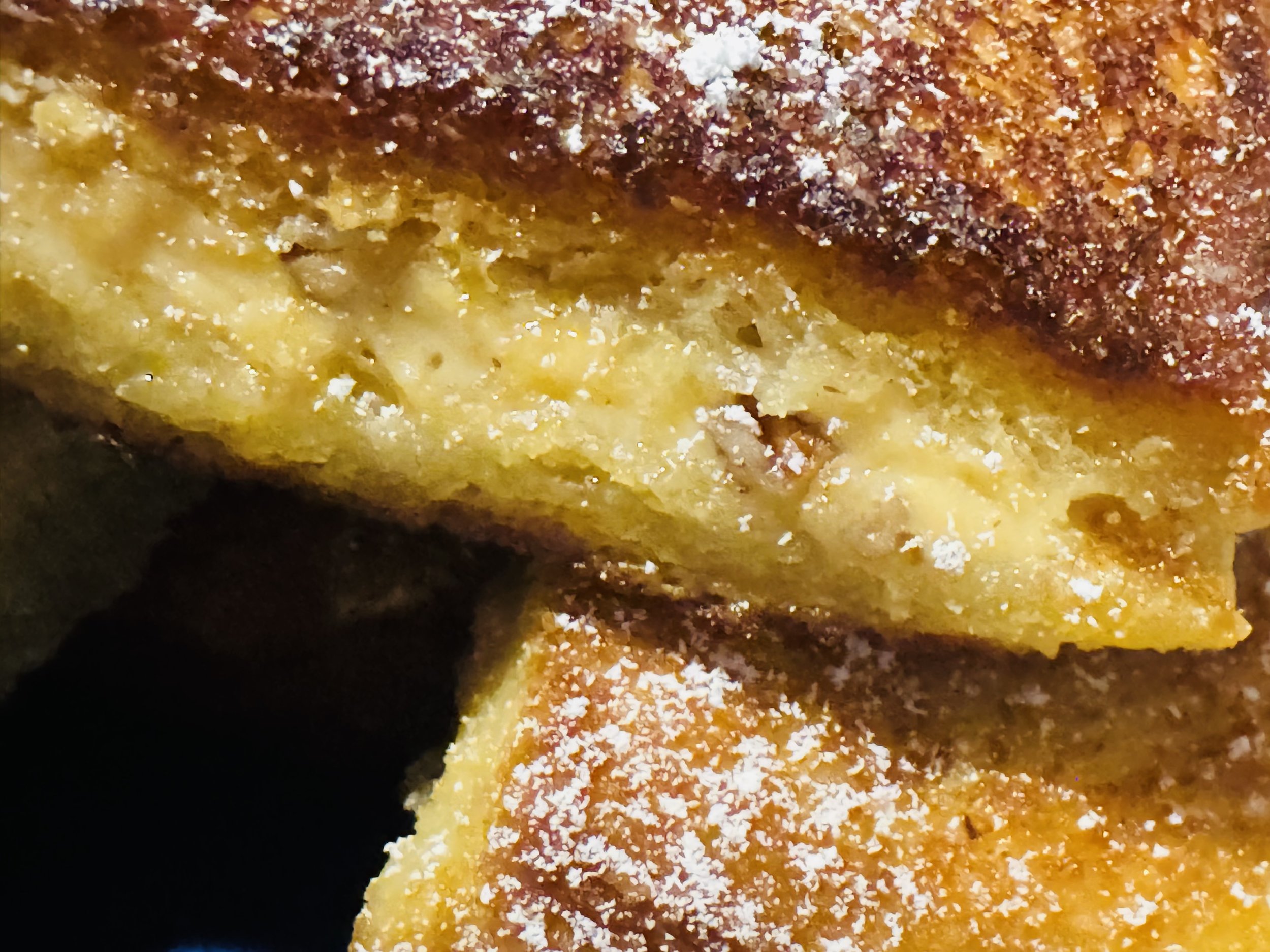 Fried cream cheese melt dusted with powdered sugar and crispy golden edges