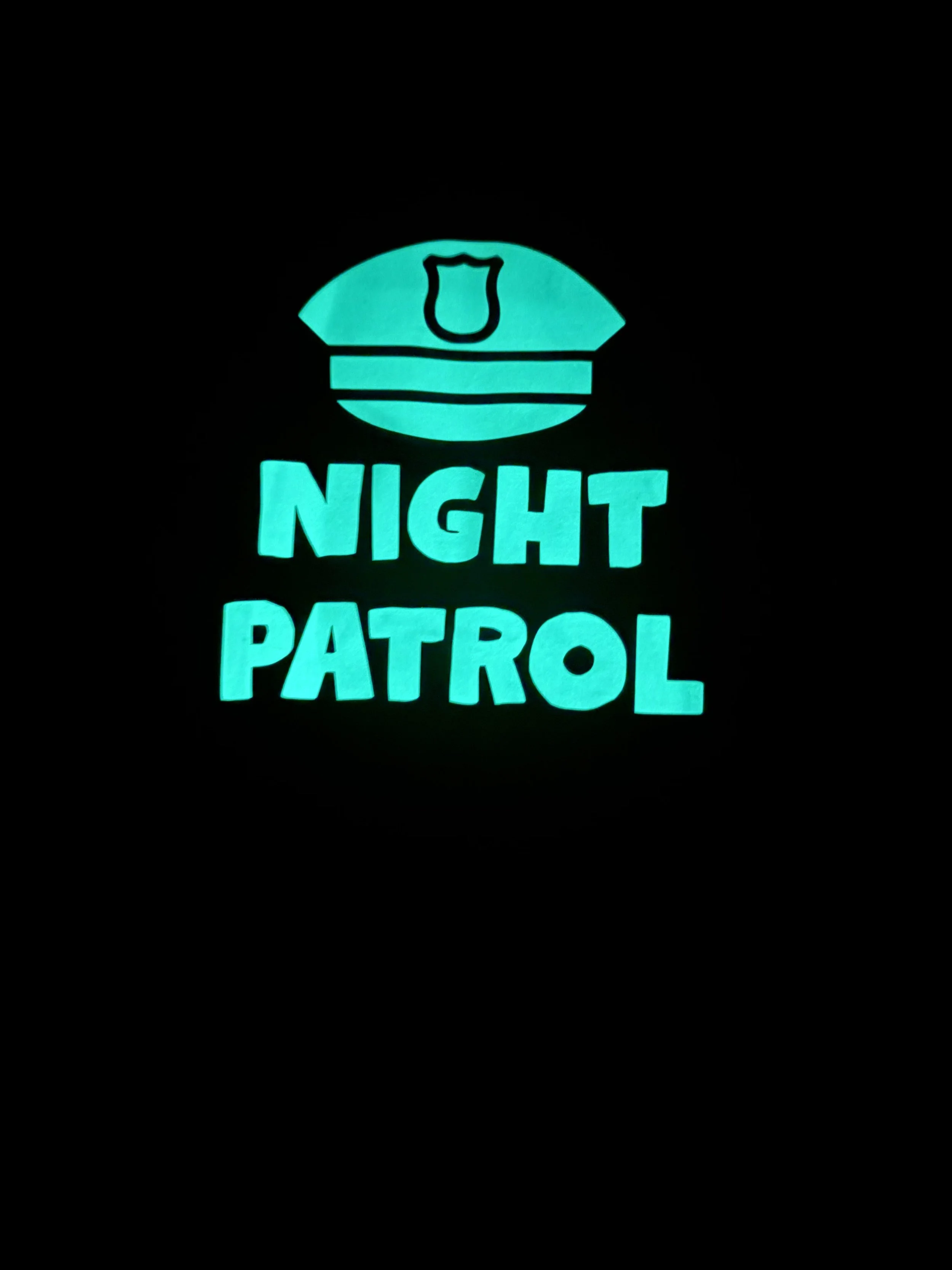Glow-in-the-dark Night Patrol dog shirt on purple polyester fabric.