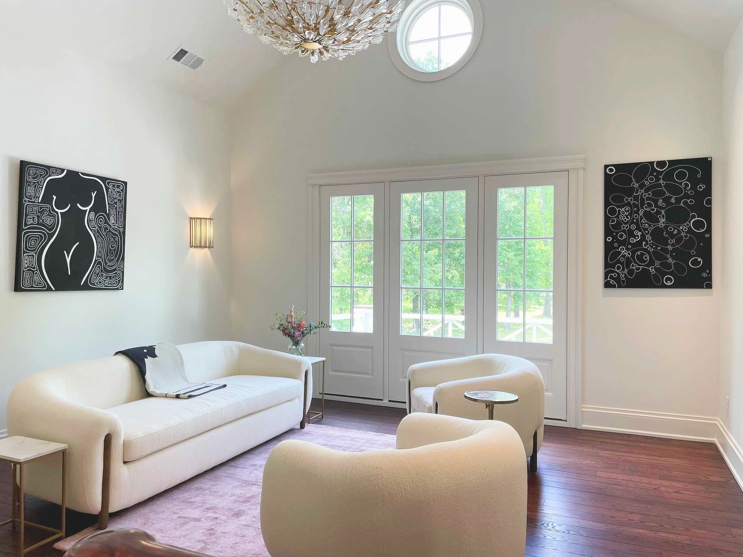 Two large abstract wall art paintings hanging on walls in a living room area.