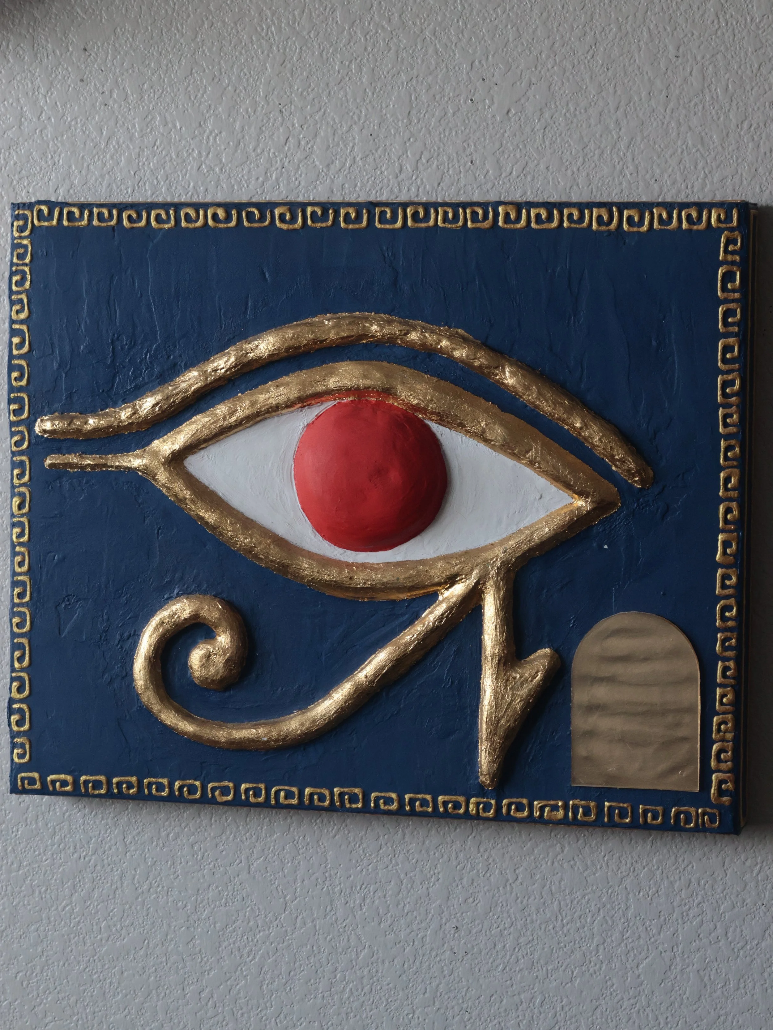 A slightly angled image of an Eye of Ra Egyptian painting.