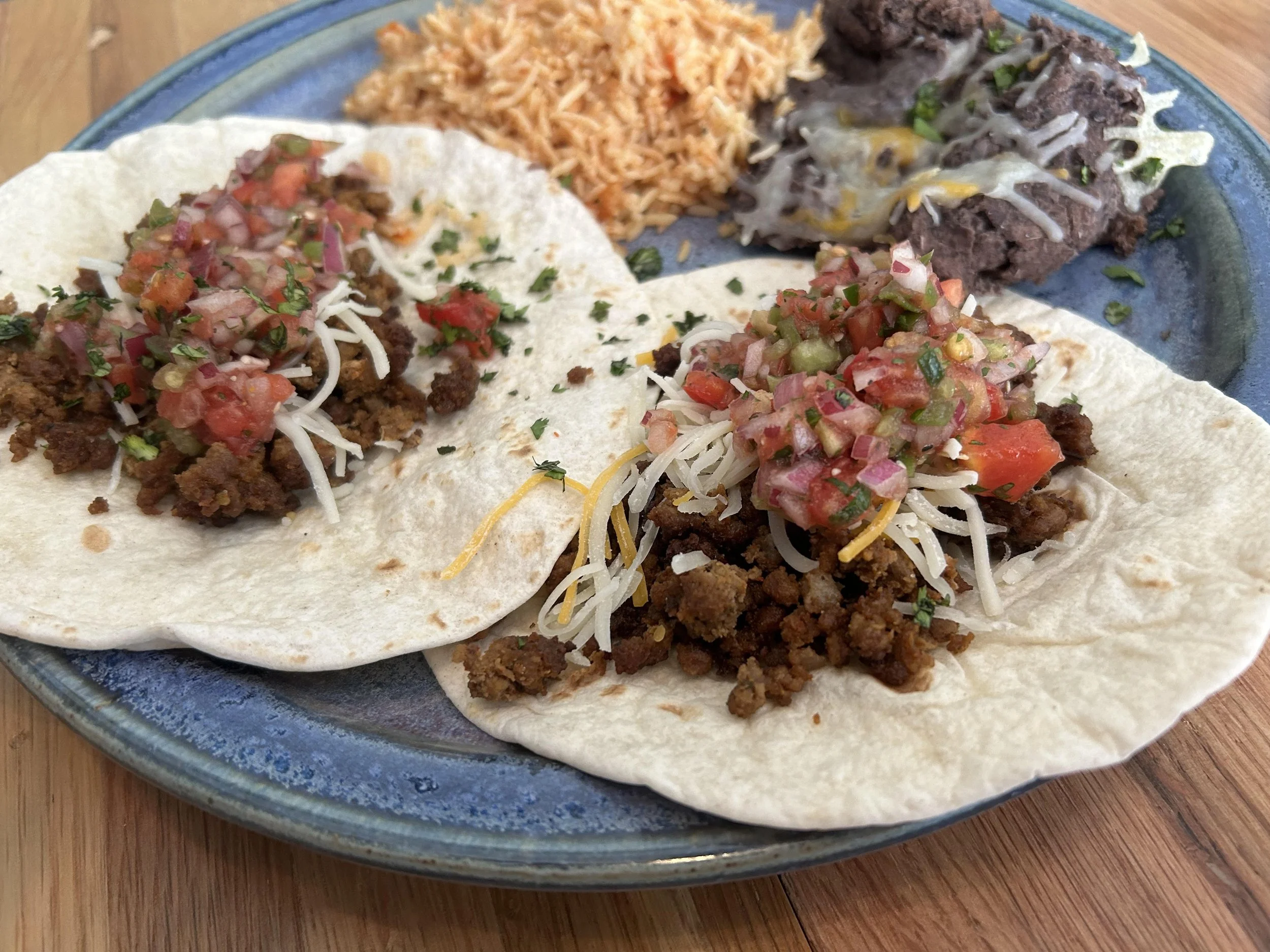 Ground Beef Tacos: 12 Ground Beef Tacos (3 per person) with house-seasoned Hopewell Farms beef, flour tortillas, shredded cheese & sour cream. Served with crispy cumin potatoes and refried black beans. Ready in 10–12 minutes.
