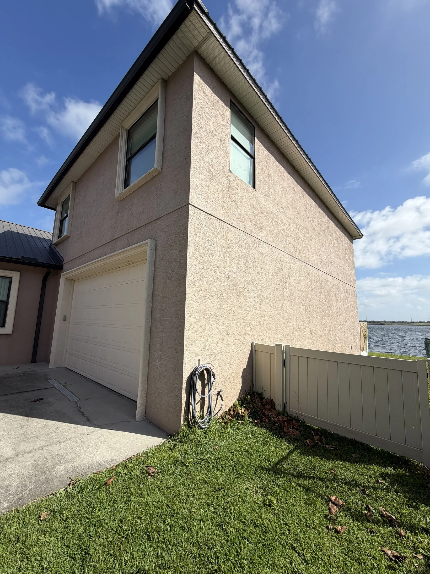 Exterior house repaint near a lake in Polk County, FL by Summit Epoxy & Painting