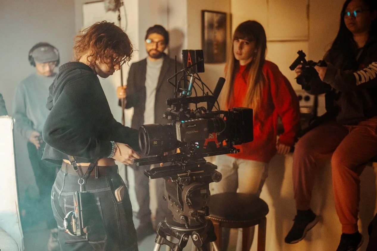 A film director and a crew preparing a shot in a indoor setting with a camera and crew members.