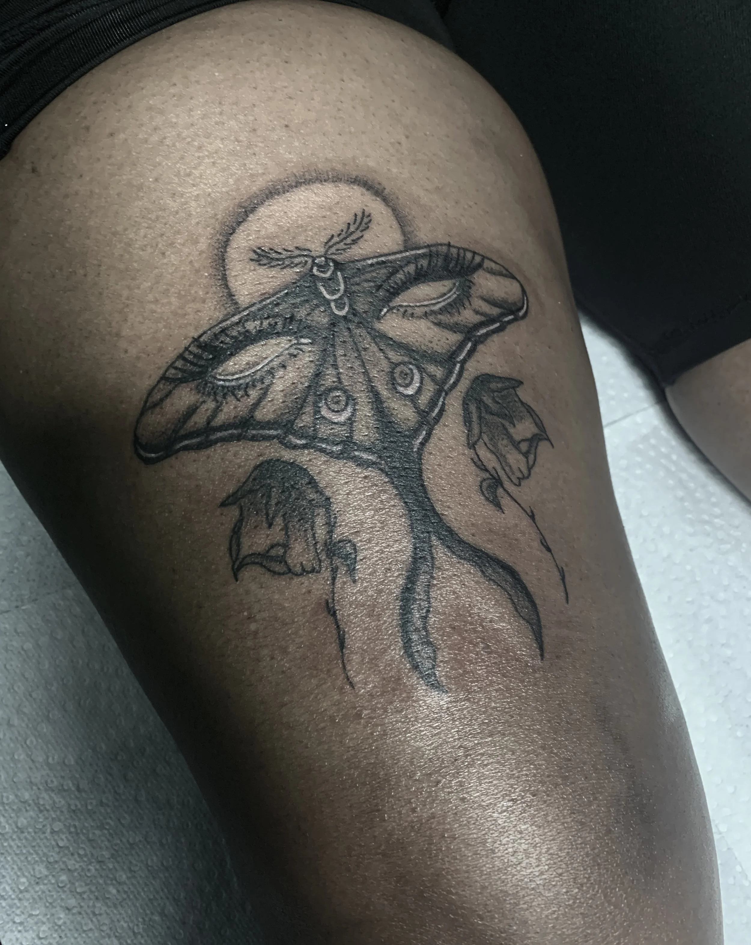 A surreal Lunar Moth tattoo with eyes on wings.