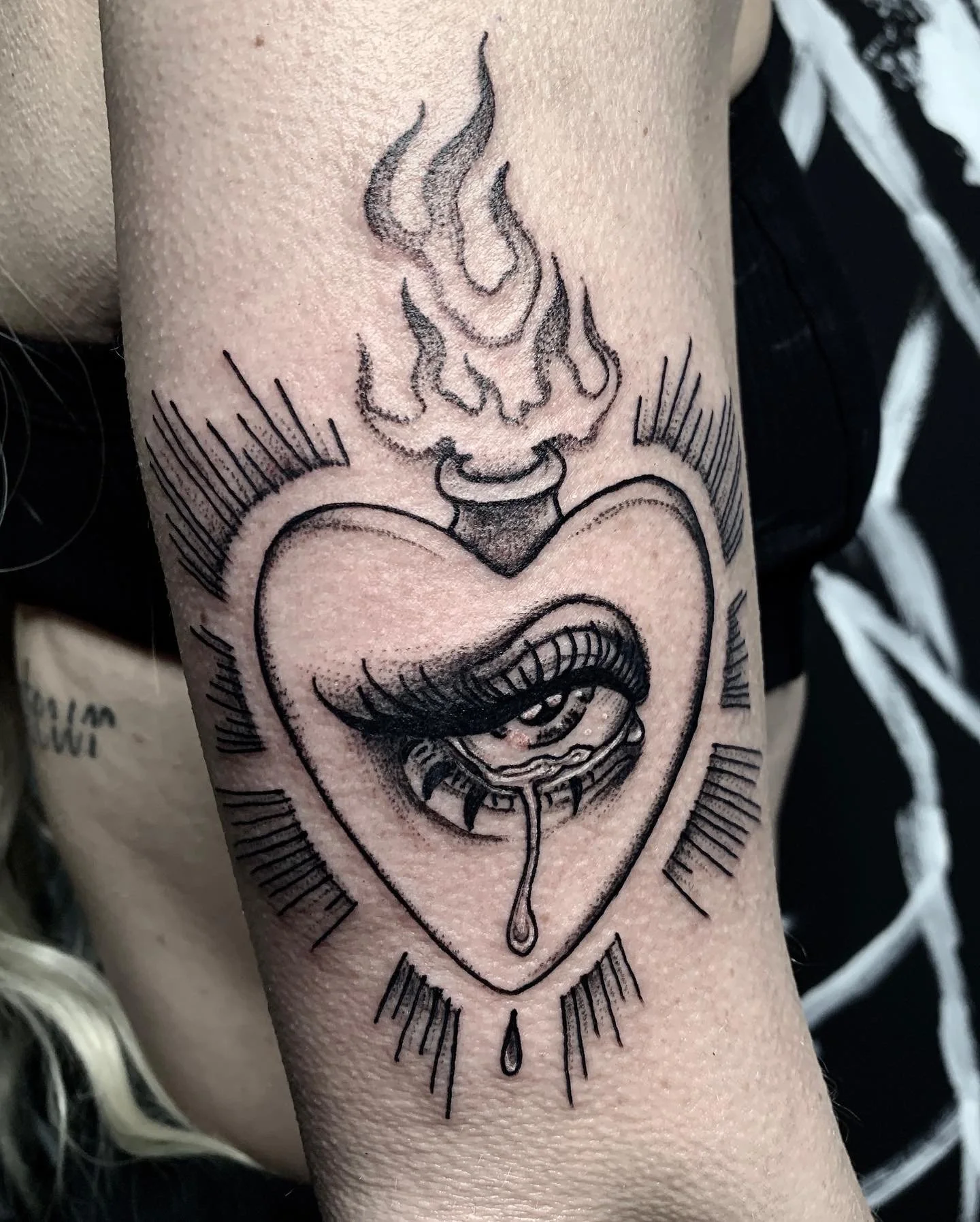 A Sacred flaming heart tattoo done in black and grey.