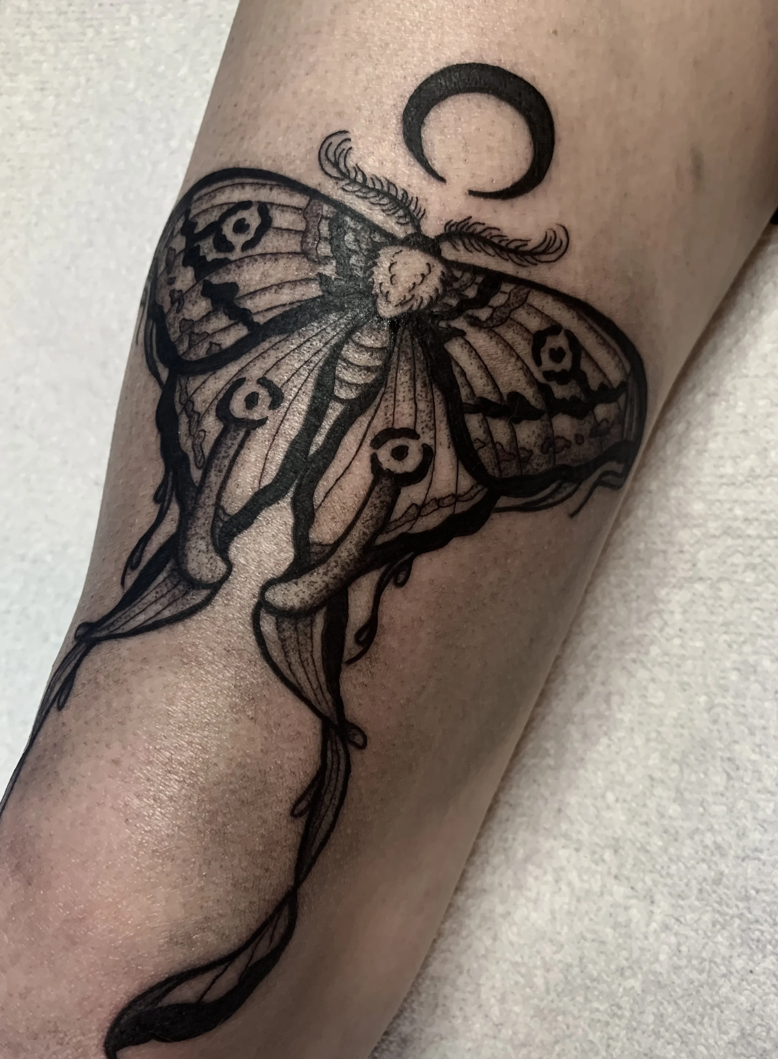 lunar moth black and grey thigh tattoo