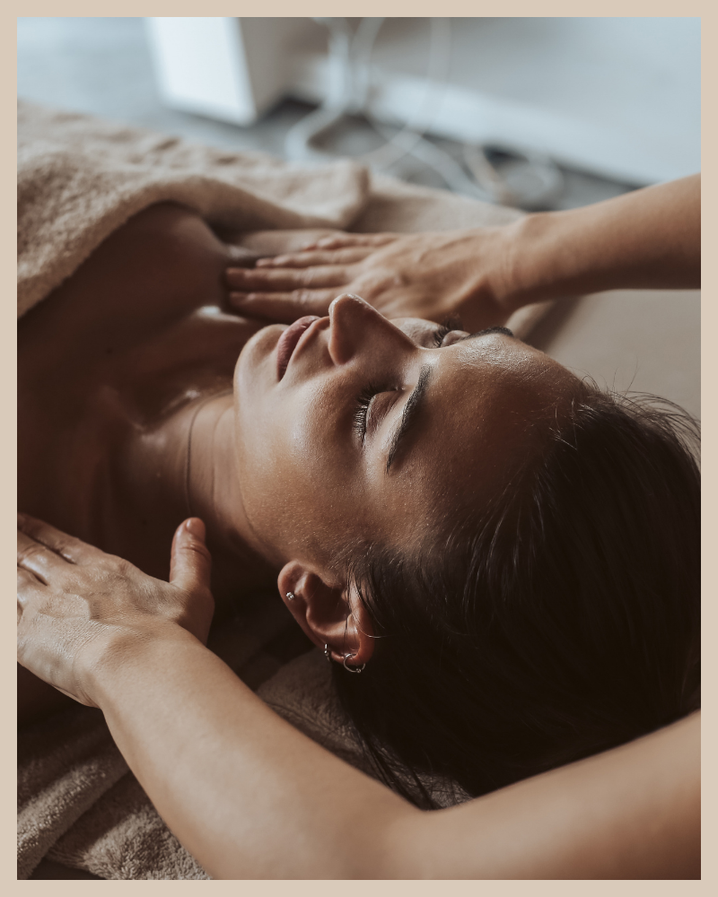 Woman receiving a relaxing massage, lying down with eyes closed and covered with a towel.