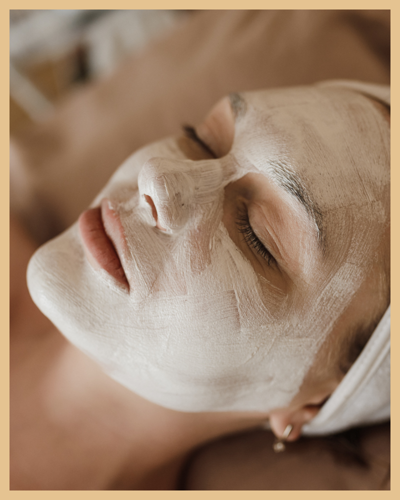 Person receiving a facial treatment with a clay mask