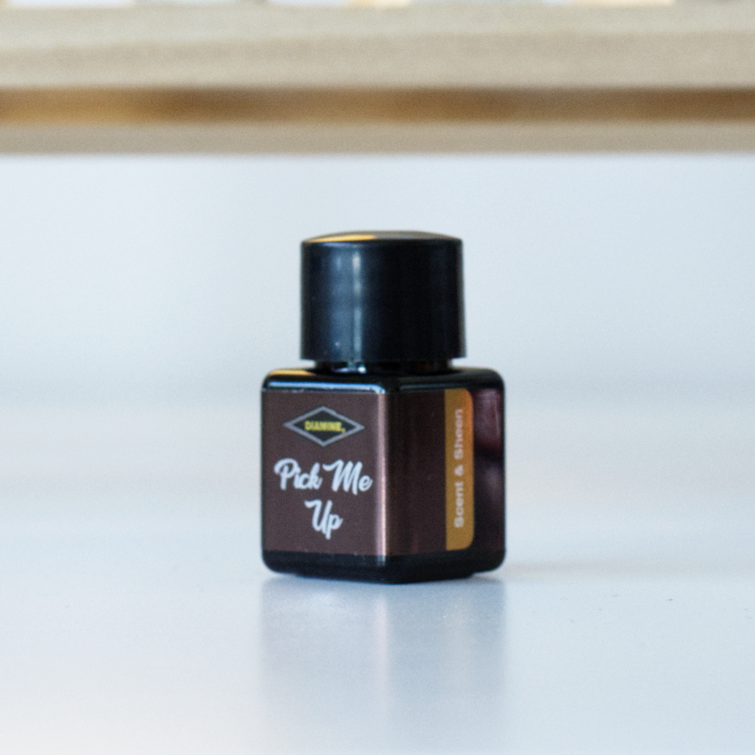 A photo of the 12mL bottle of Diamine fountain pen ink, in the colour Pick Me Up.