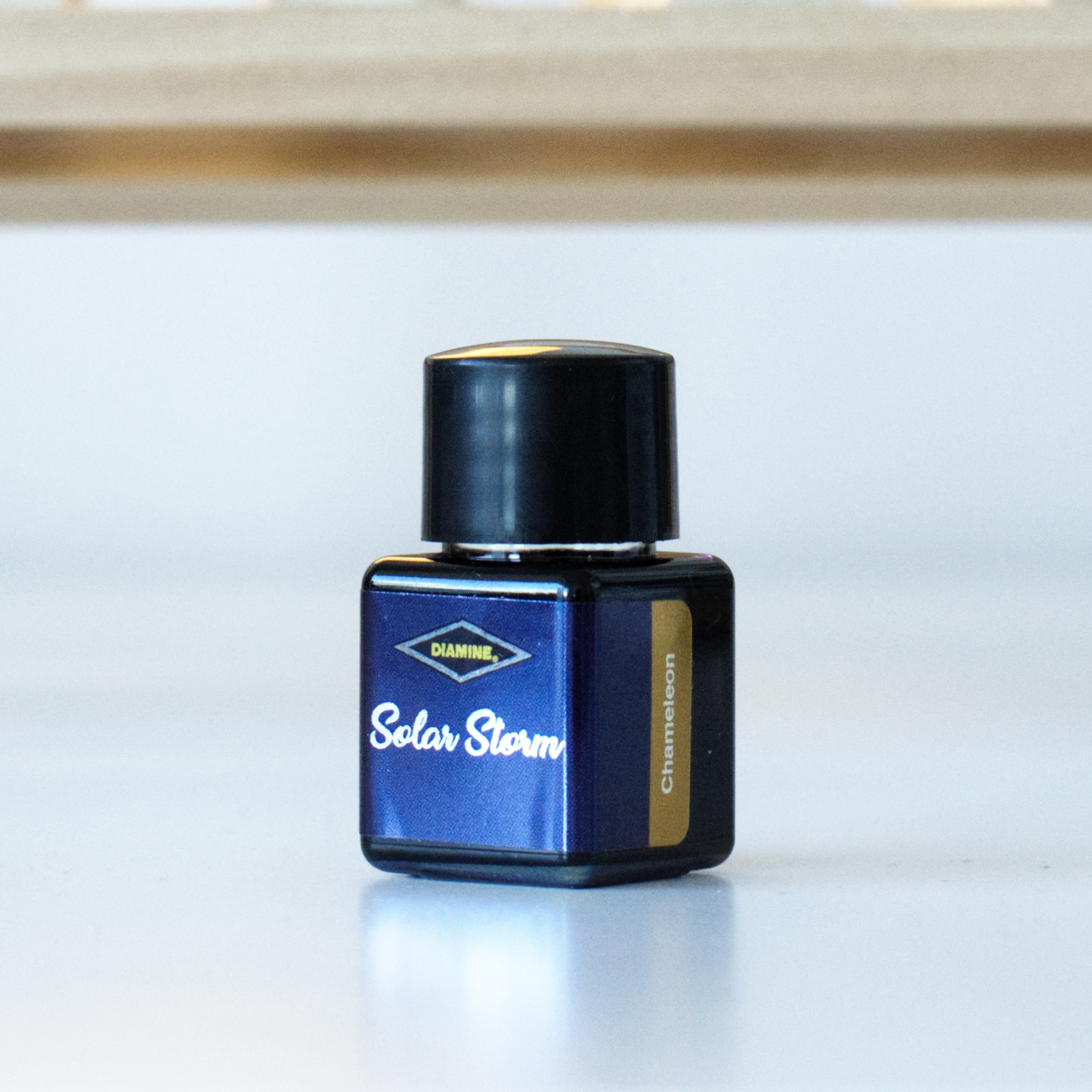 A photo of the 12mL bottle of Diamine fountain pen ink, in the colour Solar Storm.