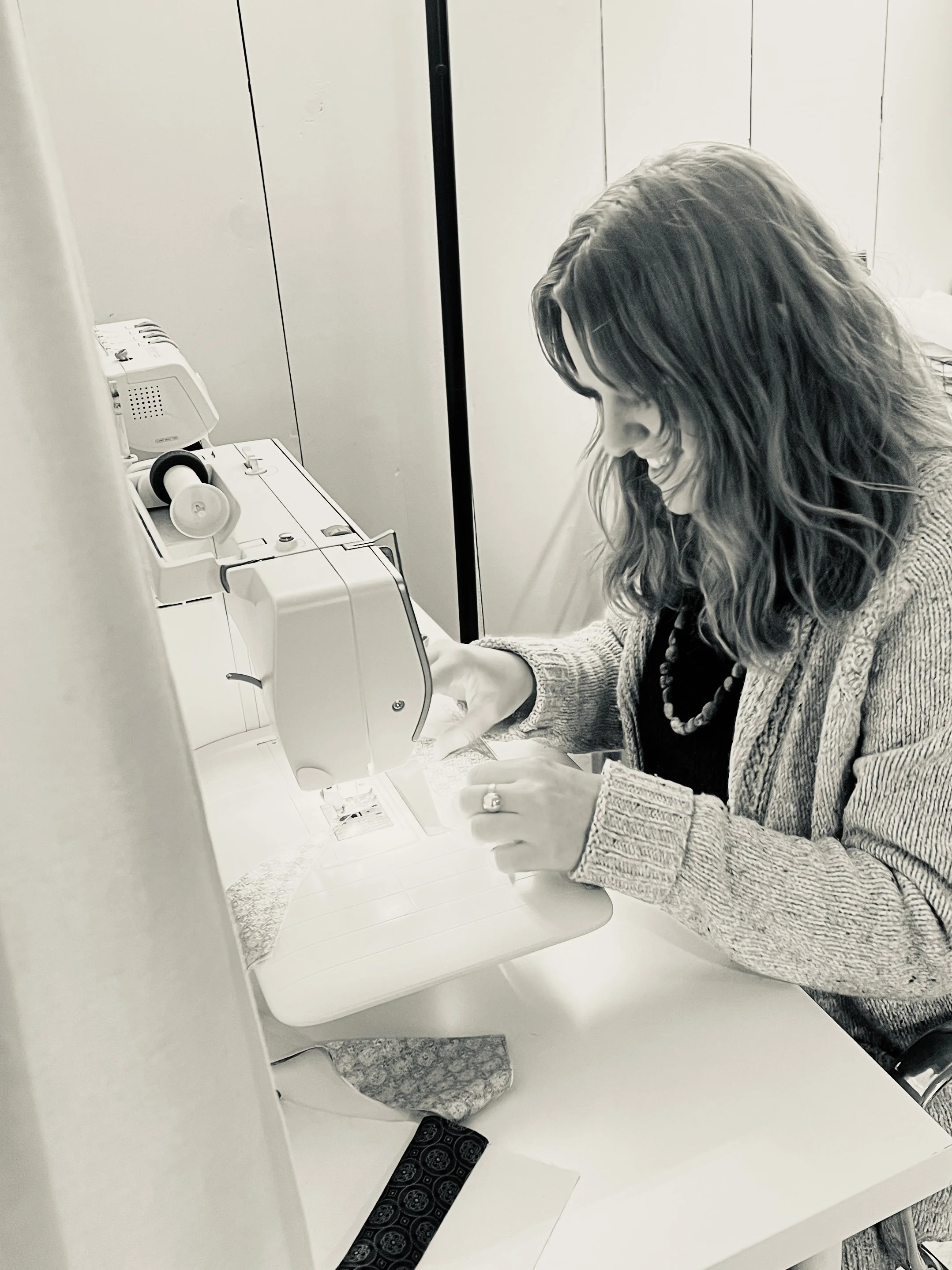 A woman using a sewing machine in a room.