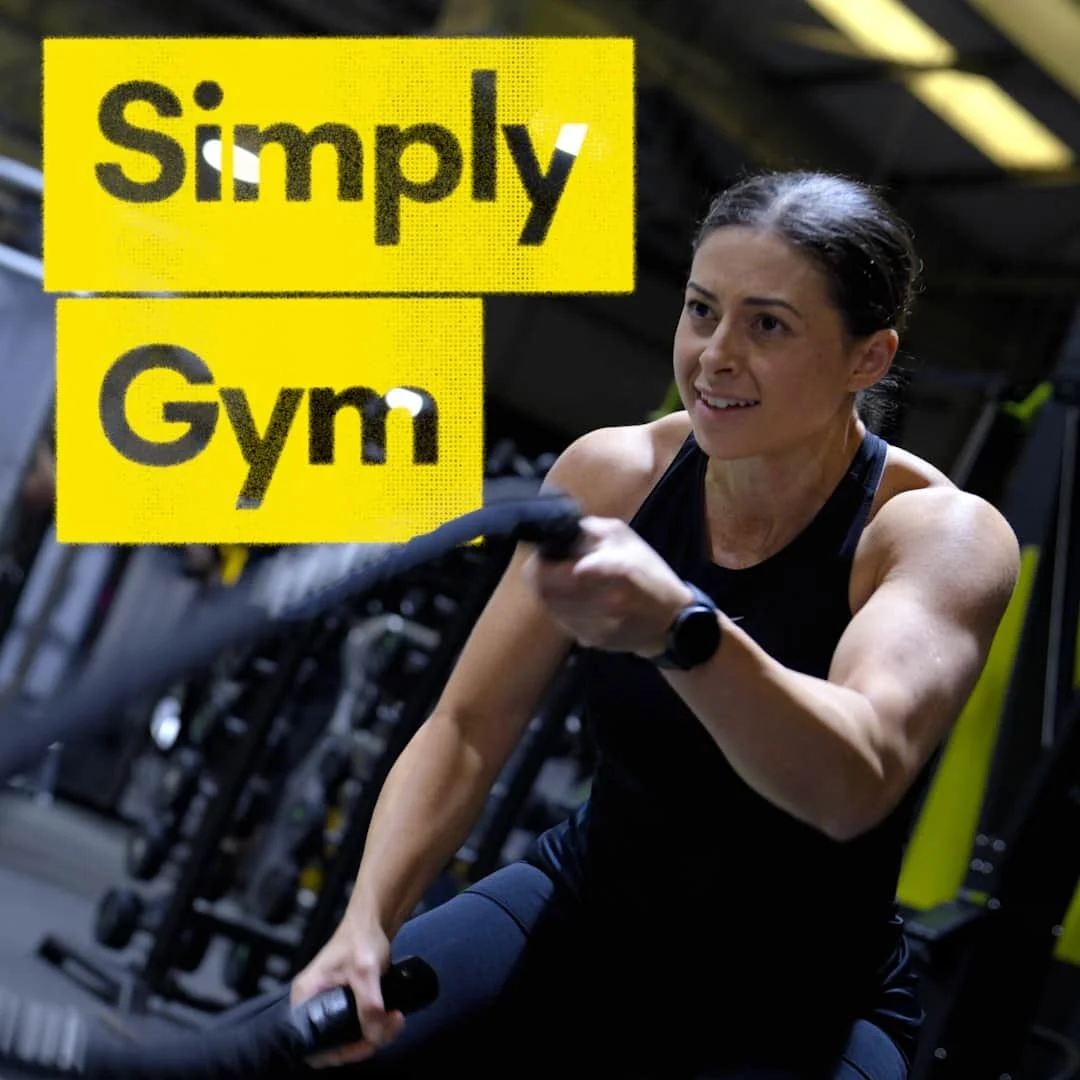 Woman exercising with battle ropes in a gym with yellow and black logo overlay that reads 'Simply Gym'.