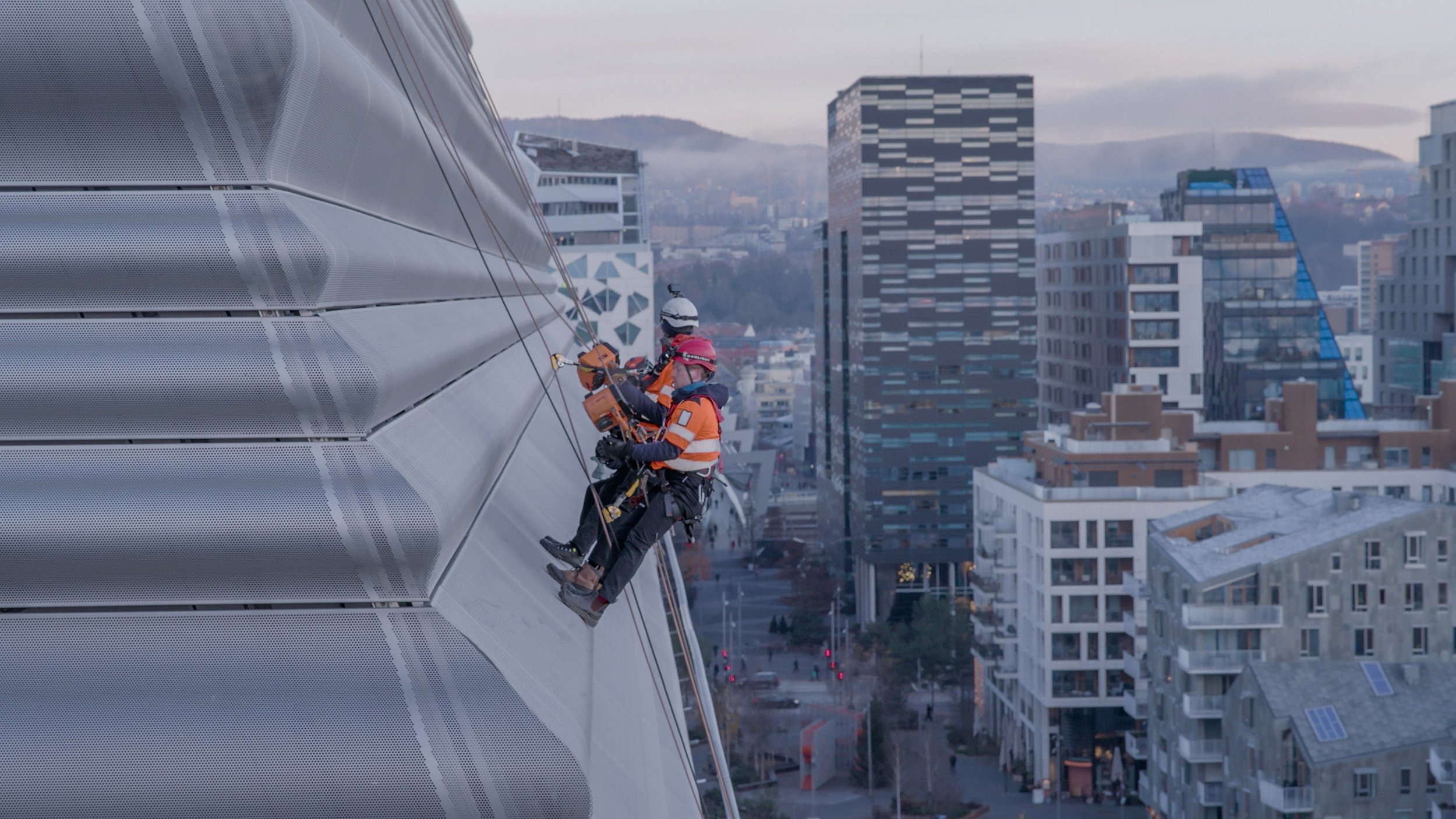 Professional rope access technicians performing facade maintenance on high-rise building