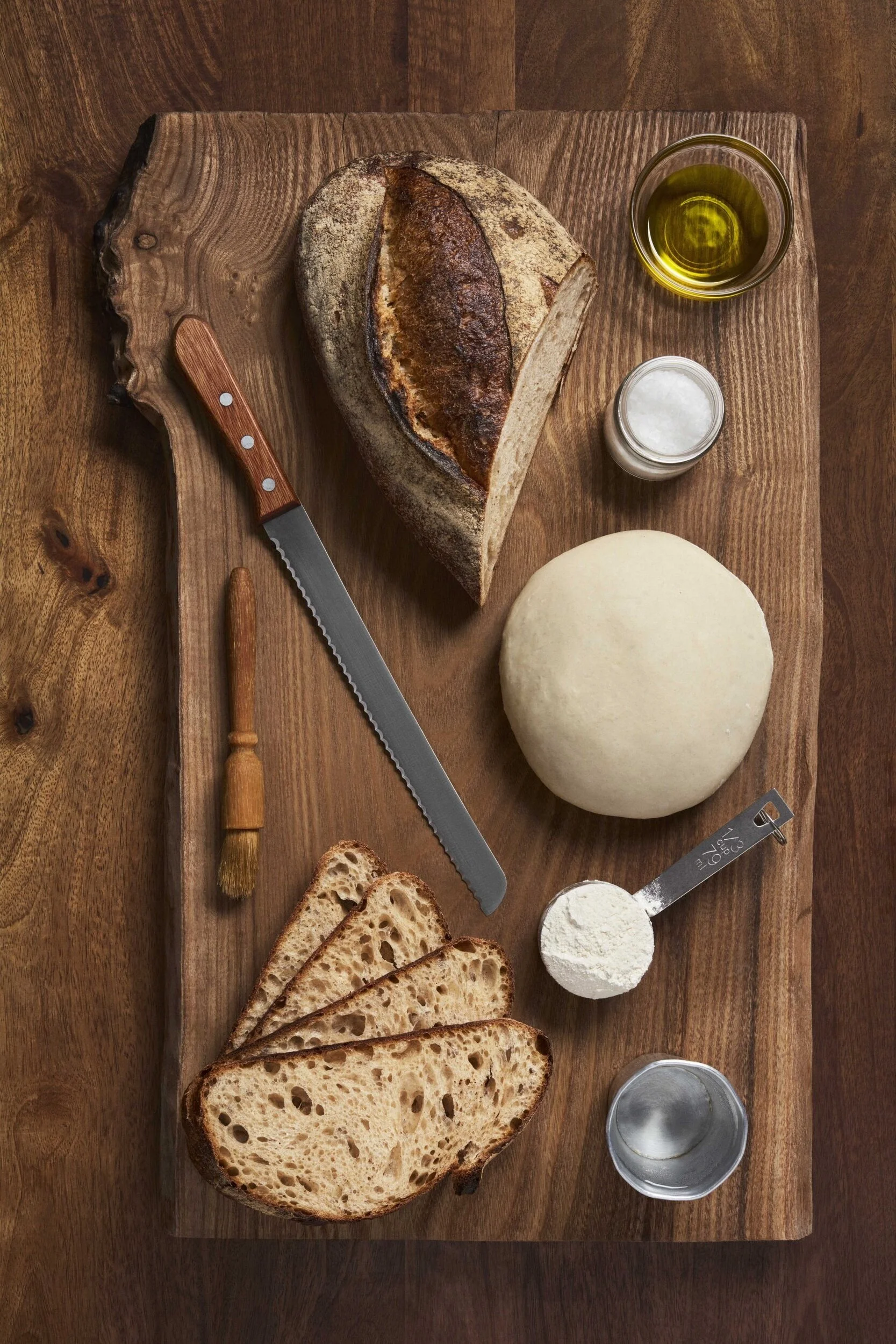 Frisch gebackenes Brot mit Zutaten auf Schneidebrett.