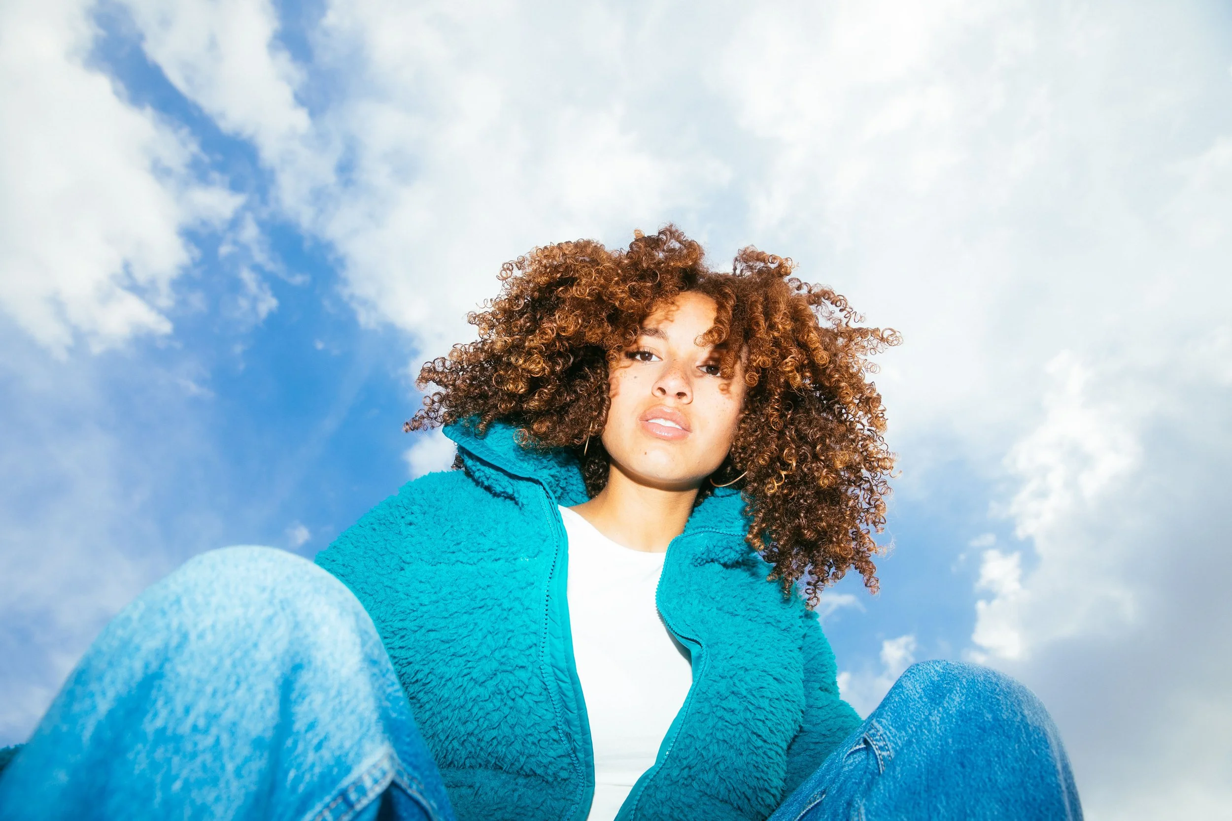 Sitzende Frau mit lockigem Haar
