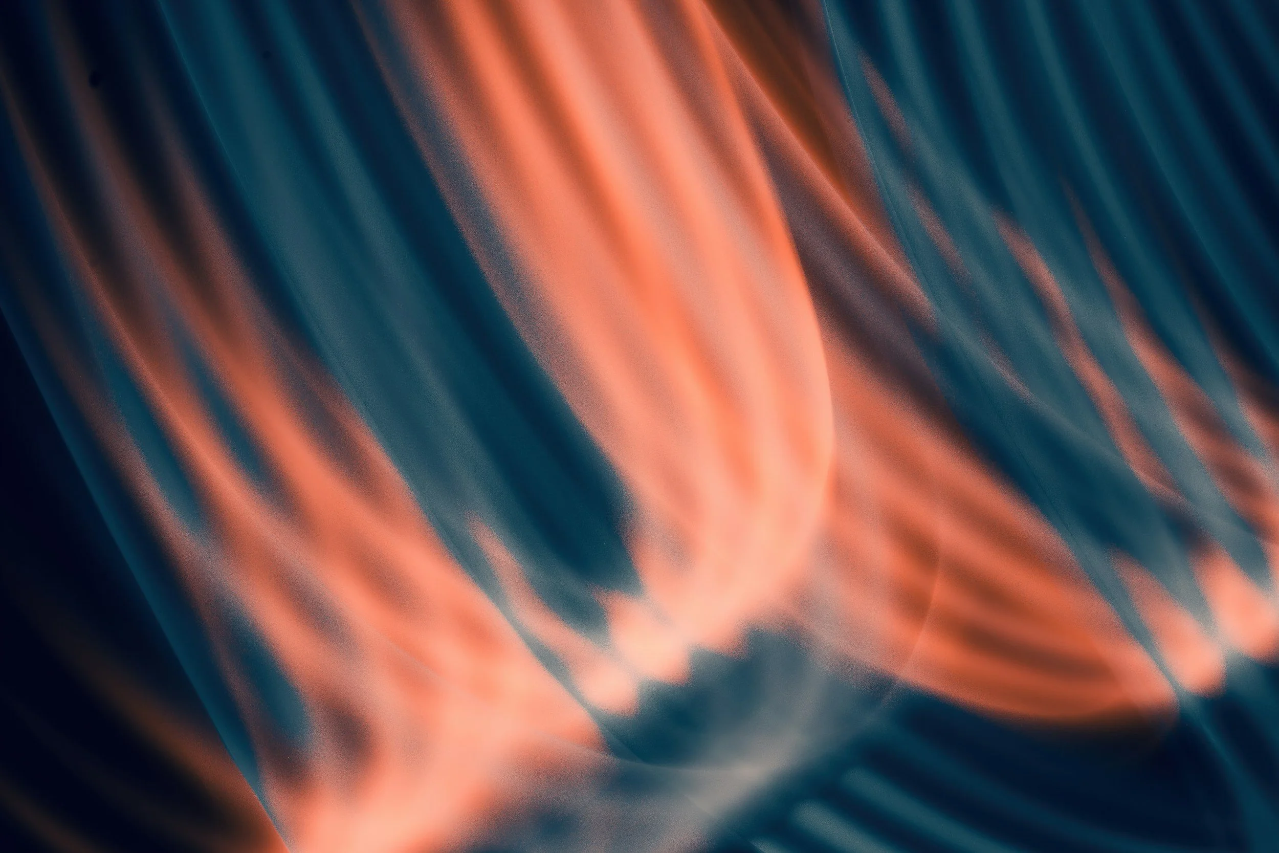 Abstract image with flowing, blurred lines in shades of orange and blue.