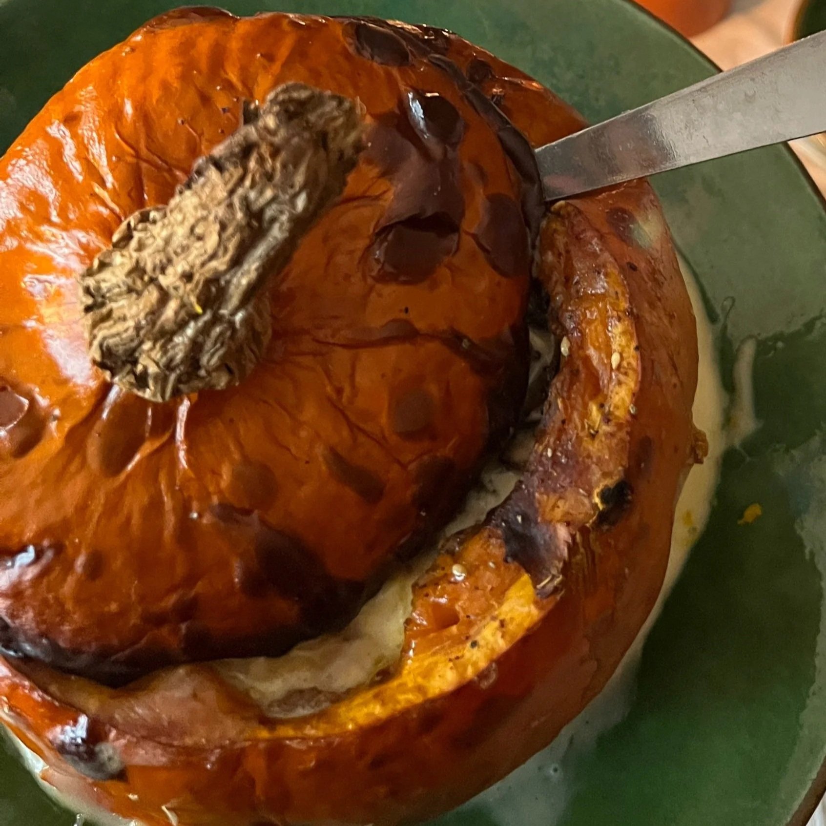 Courge butternut avec un bâton de cannelle dans un bol vert.