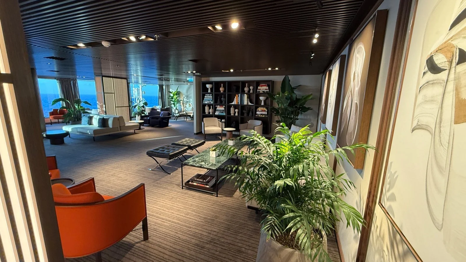 The Haven Lounge on Norwegian Luna with library shelving, seating and ocean views