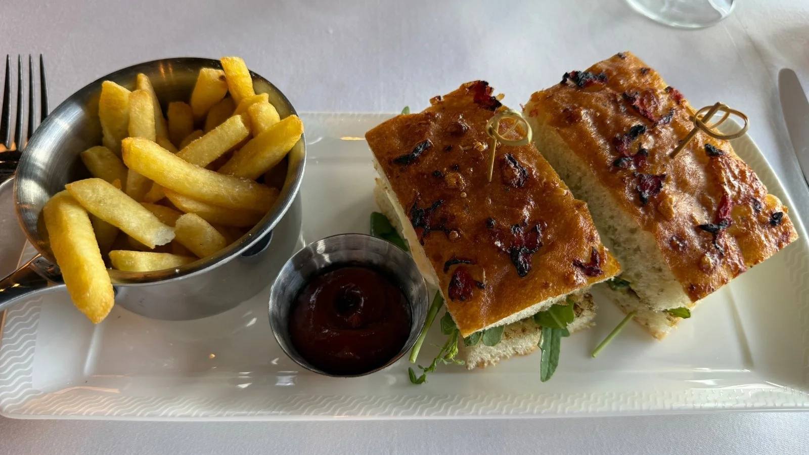 Lunch in The Haven restaurant on Norwegian Luna featuring gourmet sandwich and fries