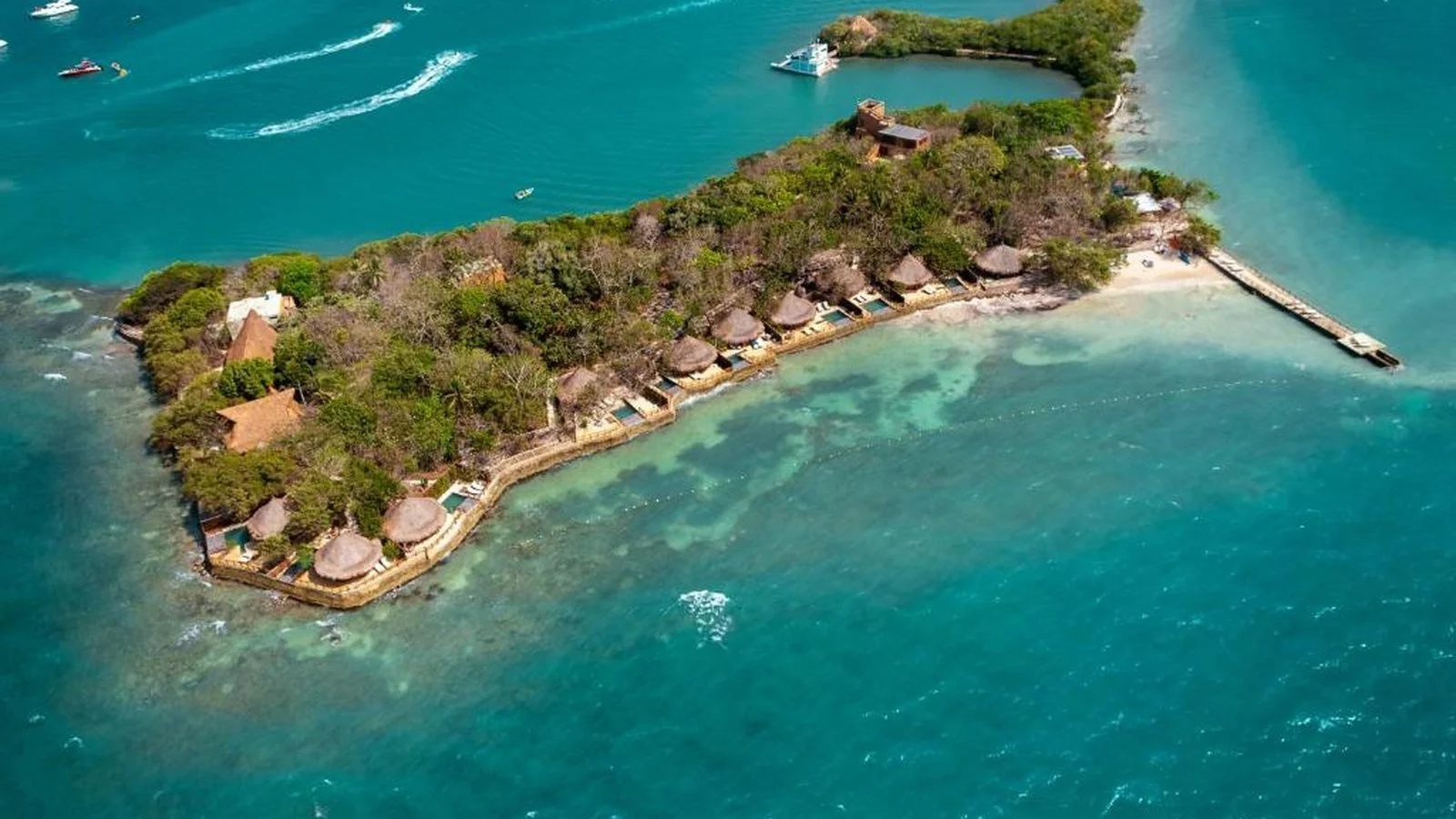 Aerial shot of Hotel Las Islas Barú near Cartagena, with luxury thatched villas along the shoreline, clear turquoise sea, and dense tropical greenery.