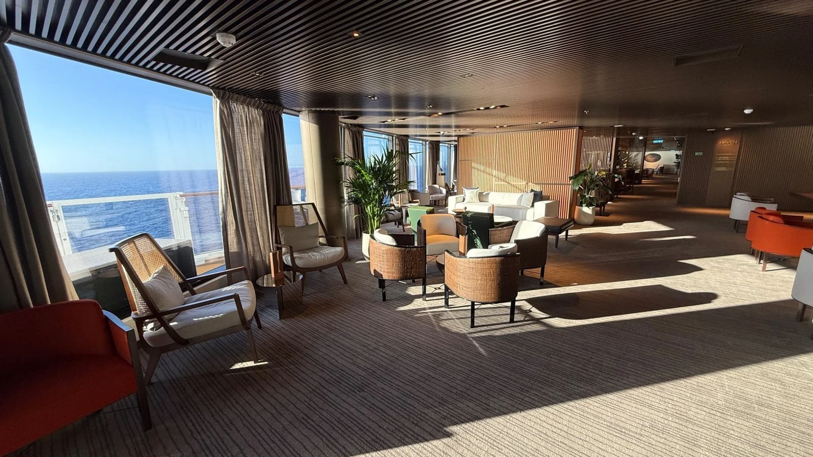 The Haven Lounge on Norwegian Luna with library shelving, seating and ocean views