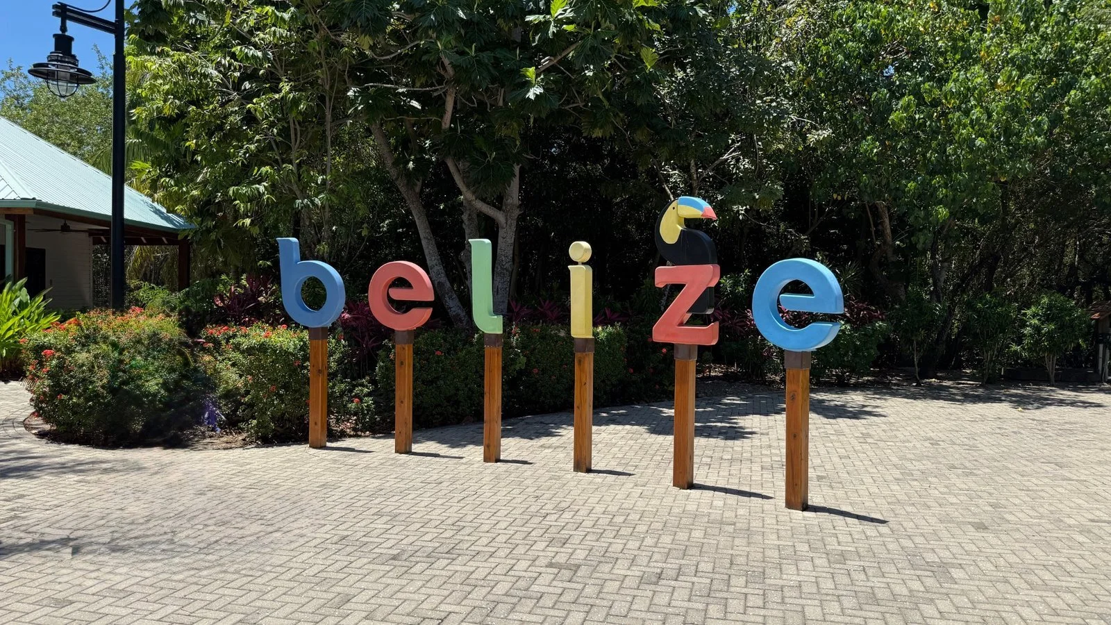 Colourful Belize sign surrounded by tropical greenery marking the entrance area on a Caribbean island