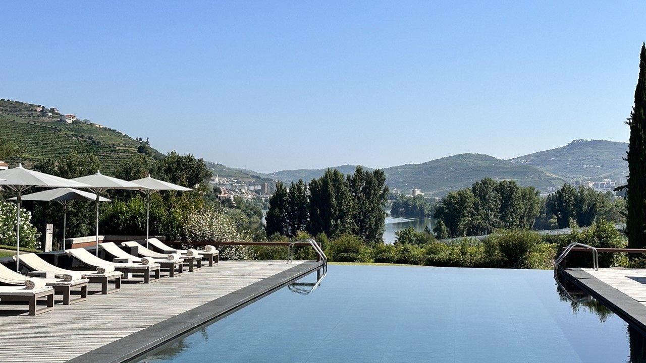 Pool with loungers and river view behind