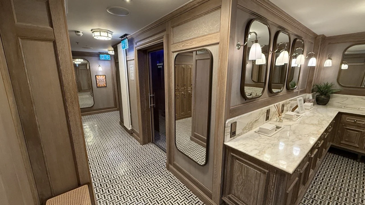 The luxurious spa area at The Strong Rooms in Gleneagles Townhouse, featuring a marble vanity with elegant mirrors, soft lighting, and an entrance to the infrared sauna.