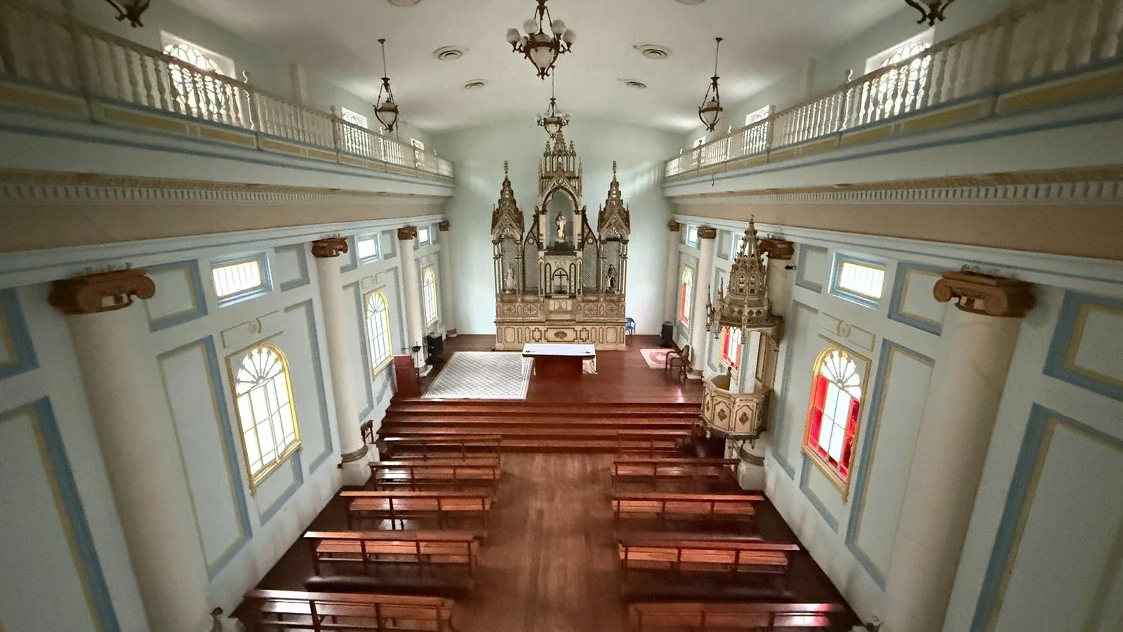 Colonial-era chapel interior with wooden pews, ornate altar and soft pastel detailing in historic Guayaquil