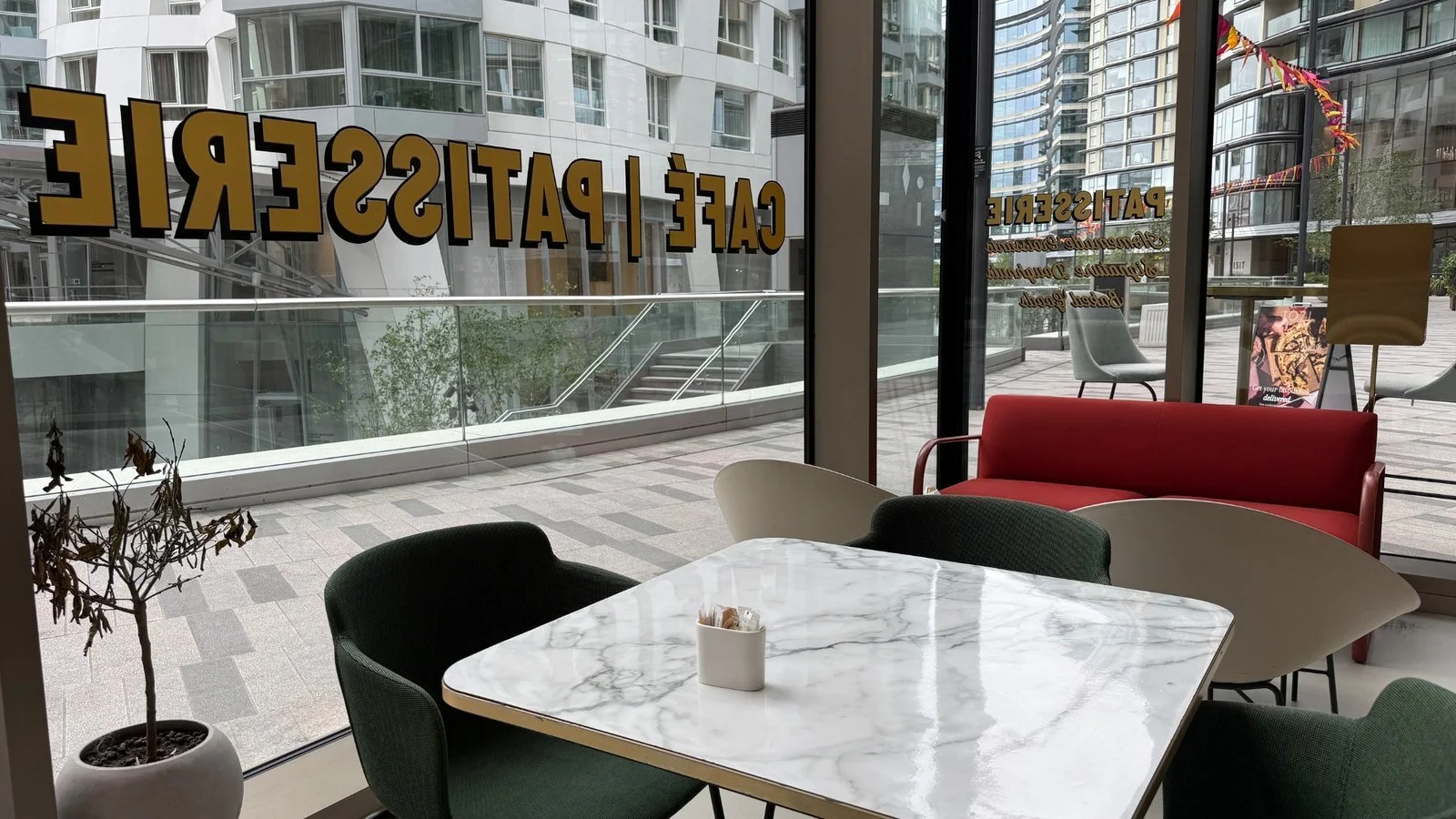 Interior seating area at TOZI Counter café inside art’otel London Battersea Power Station overlooking Electric Boulevard.