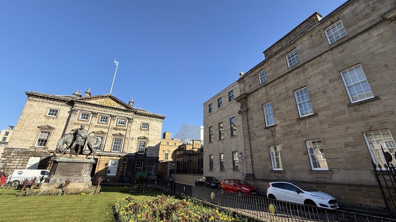 St Andrew Square in Edinburgh, featuring a historic statue and beautifully maintained gardens.
