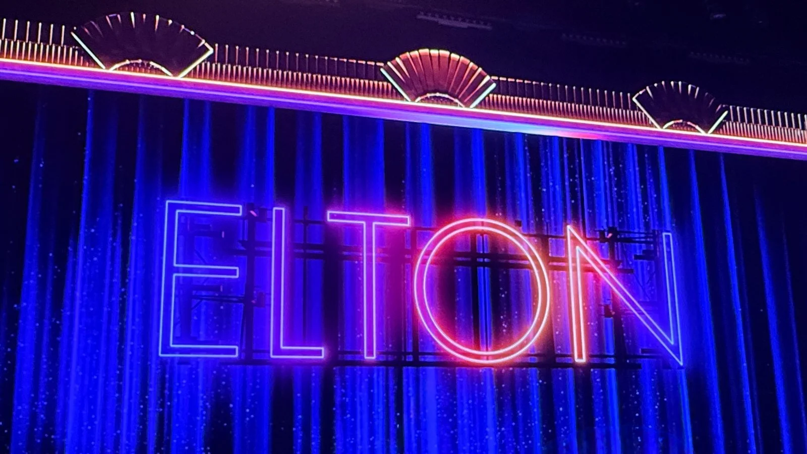 Neon Elton show sign inside a cruise ship entertainment venue with vibrant lighting and stage backdrop