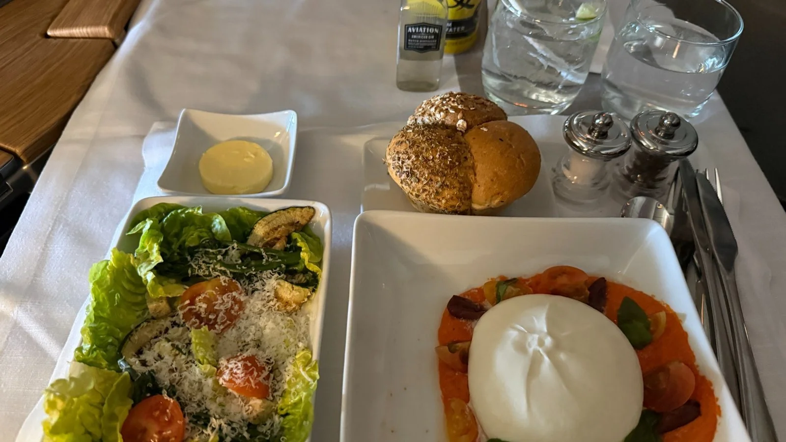 American Airlines first class dining service with burrata, salad and bread onboard Boeing 777-300ER