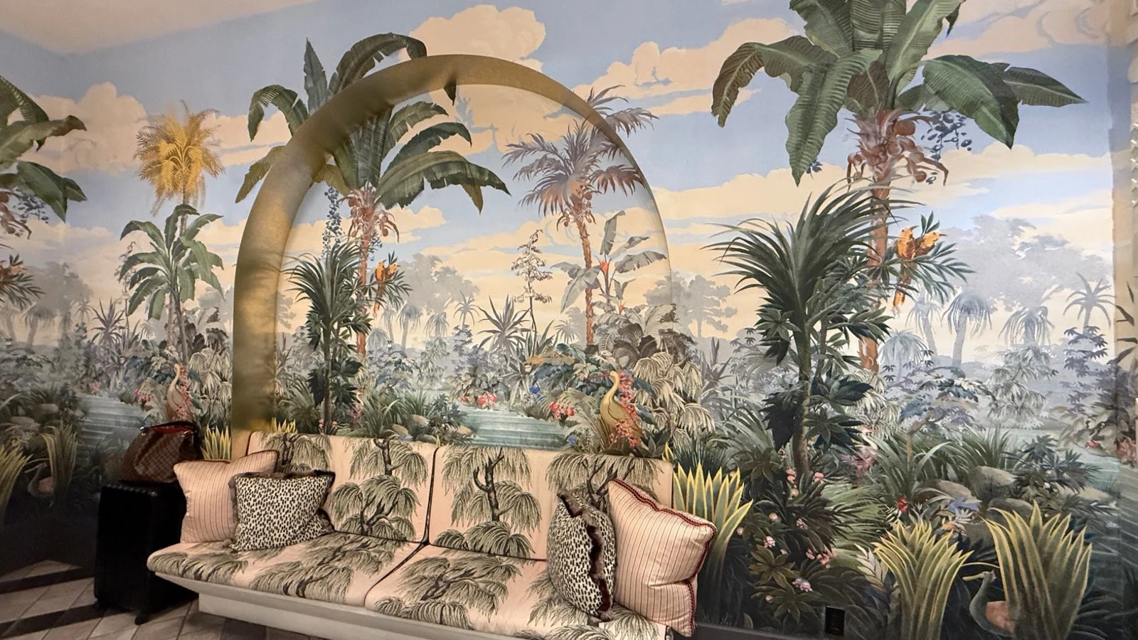 Tropical mural lounge seating at The Goodtime Hotel Miami with palm-themed artwork and patterned sofa