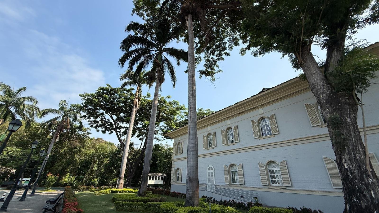 Restored colonial building surrounded by palm trees and gardens in Parque Histórico Guayaquil