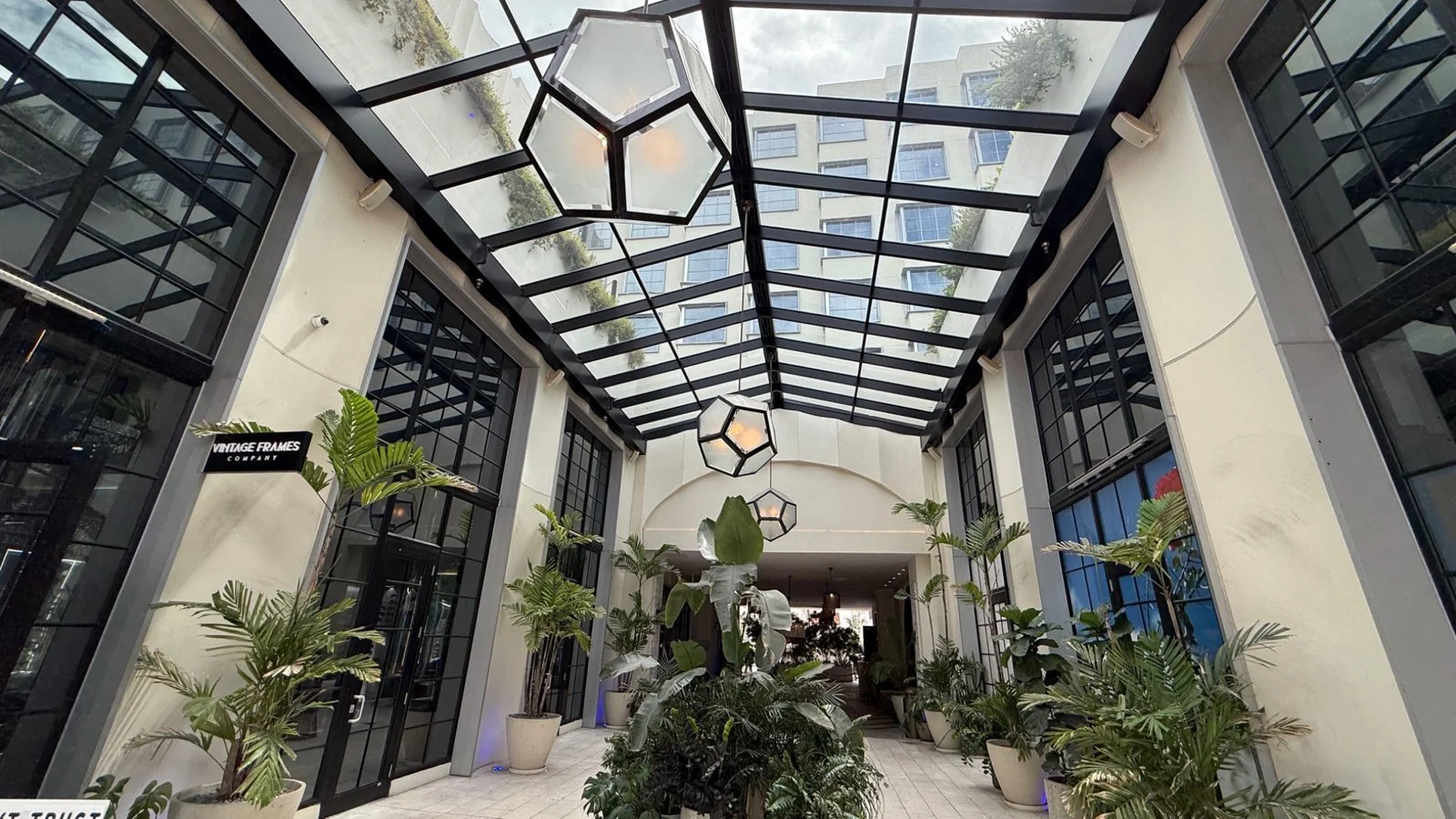 Glass-roof courtyard entrance at The Goodtime Hotel Miami with tropical plants and modern architectural design
