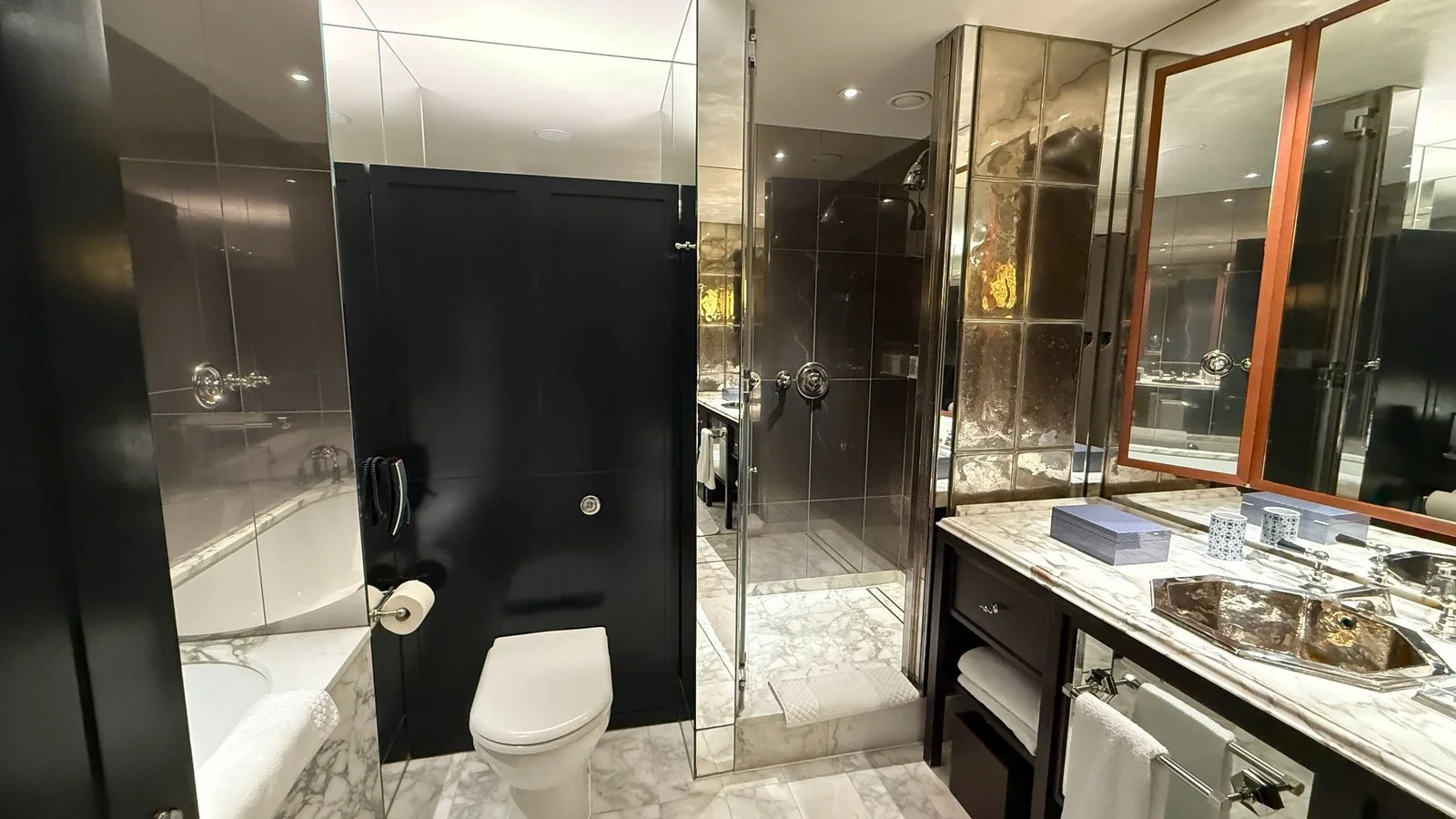 Marble bathroom with walk-in shower and vanity at Rosewood London