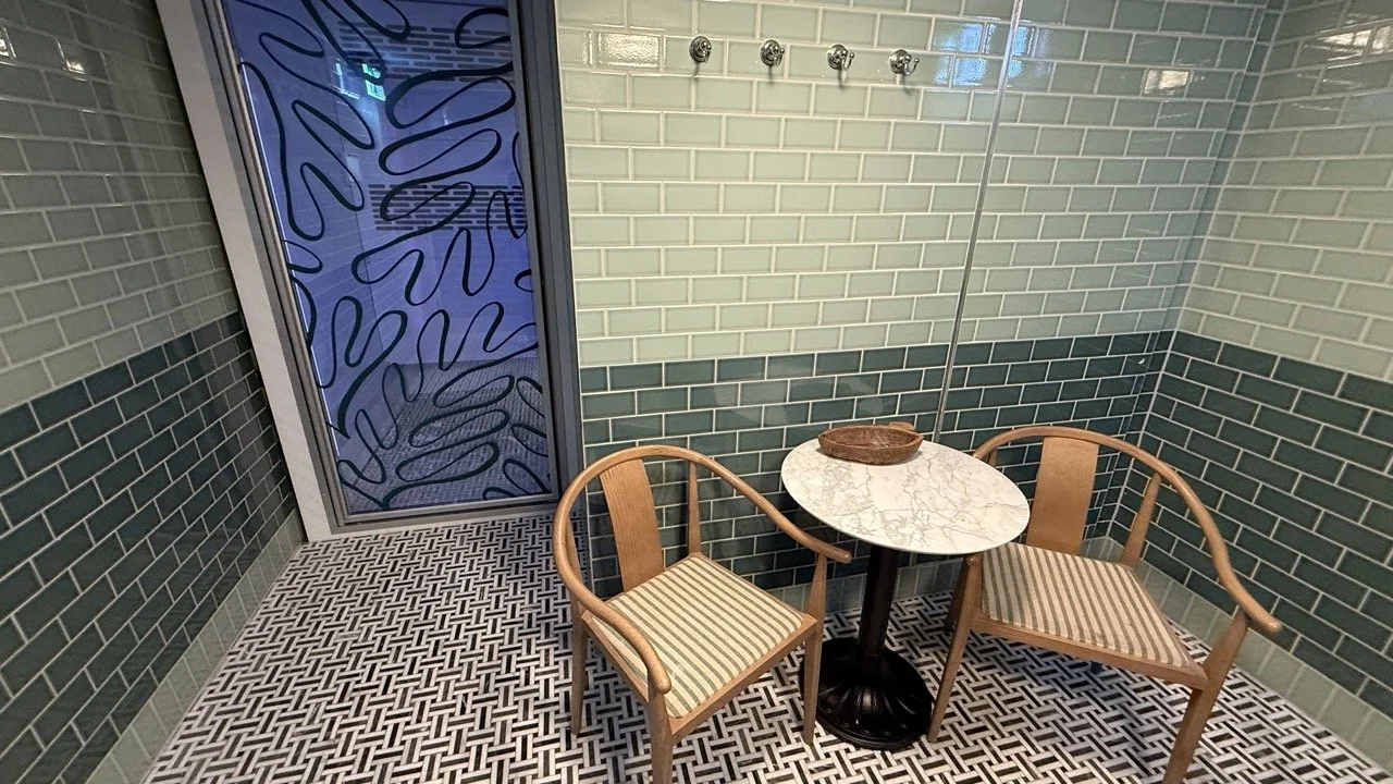 The cryotherapy room at The Strong Rooms in Gleneagles Townhouse, featuring a glass door with artistic frosted patterns and a sleek tiled interior.
