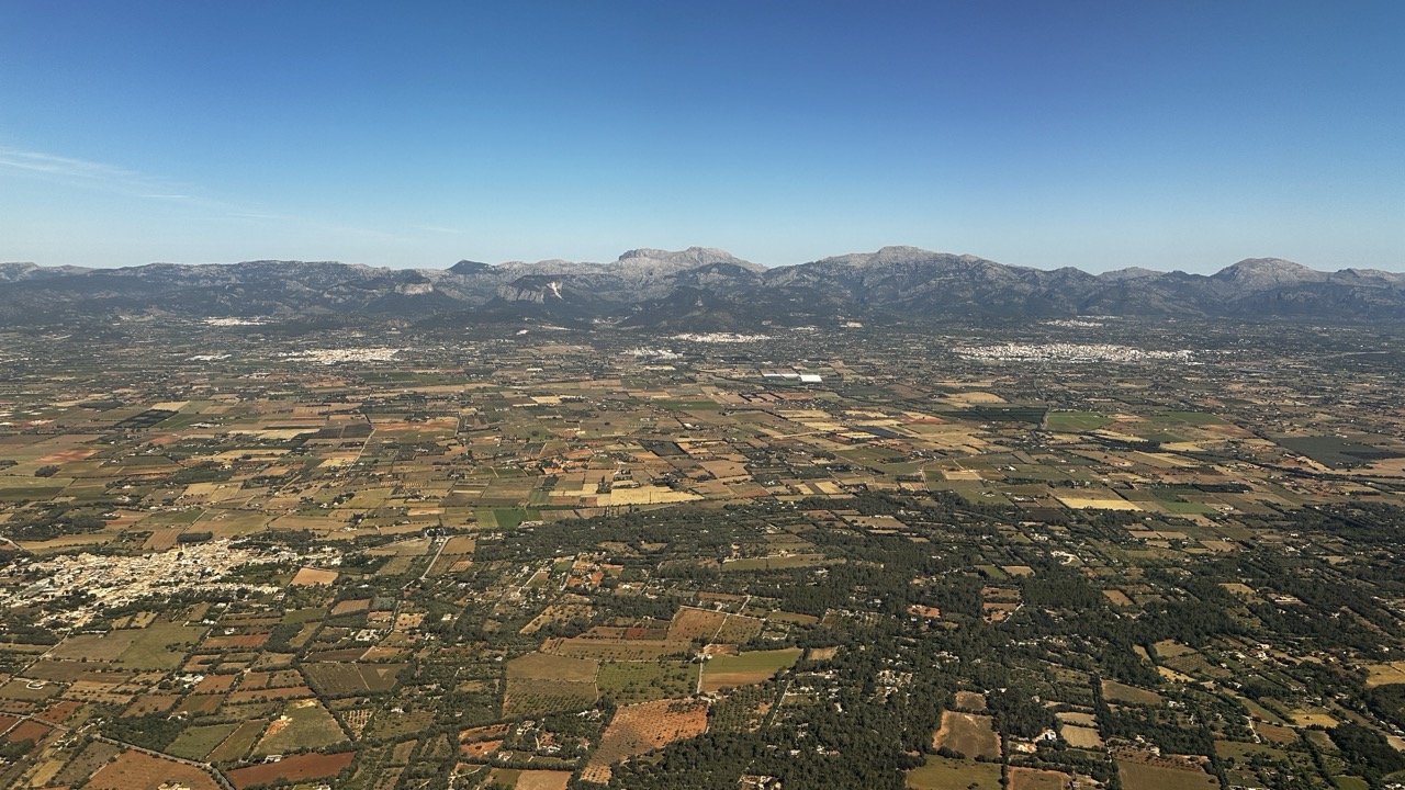 Aerial view from the flight across Mallorcan fields and blue sky